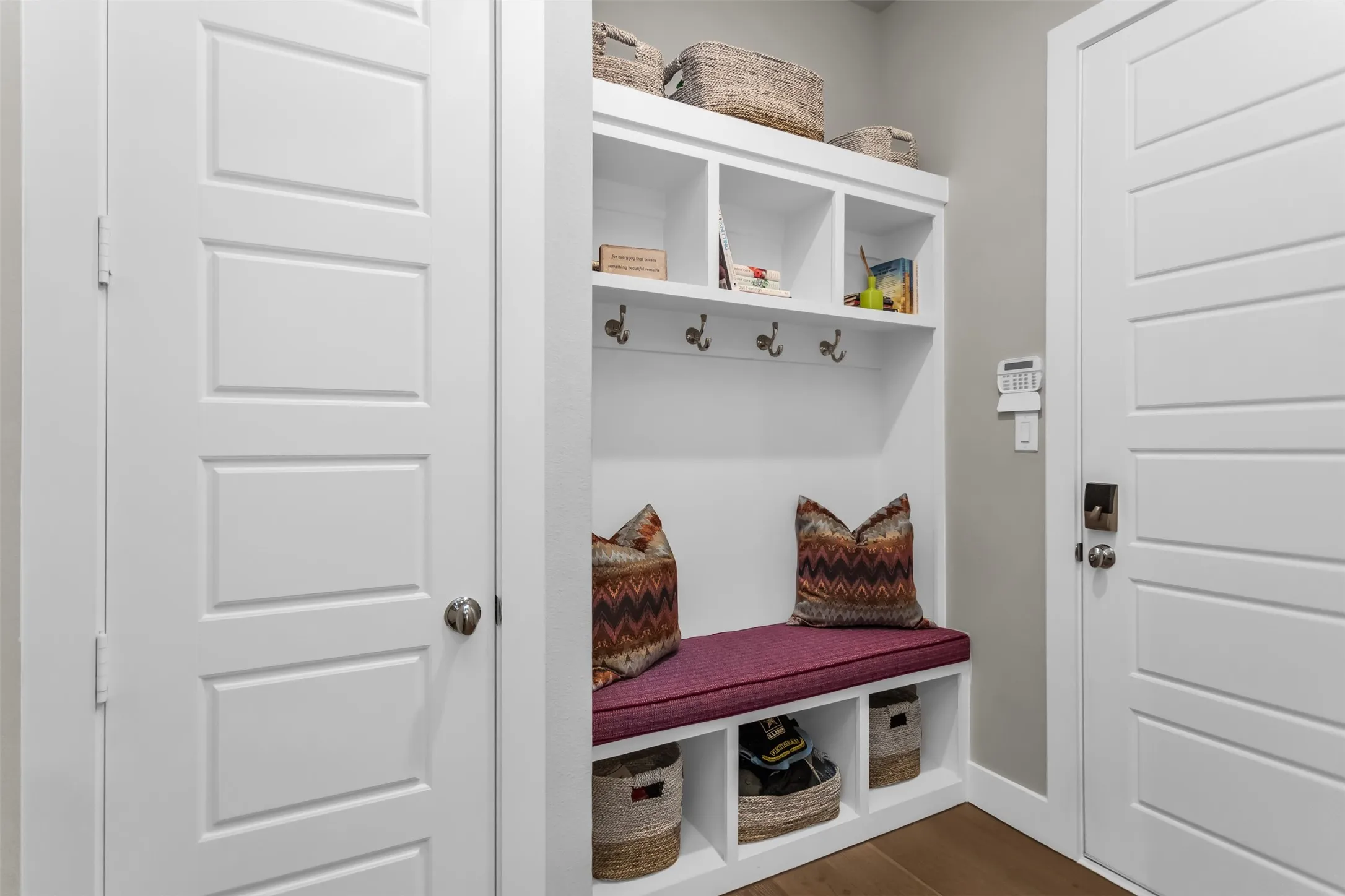 Built-in mudroom bench with storage cubbies and upper shelving