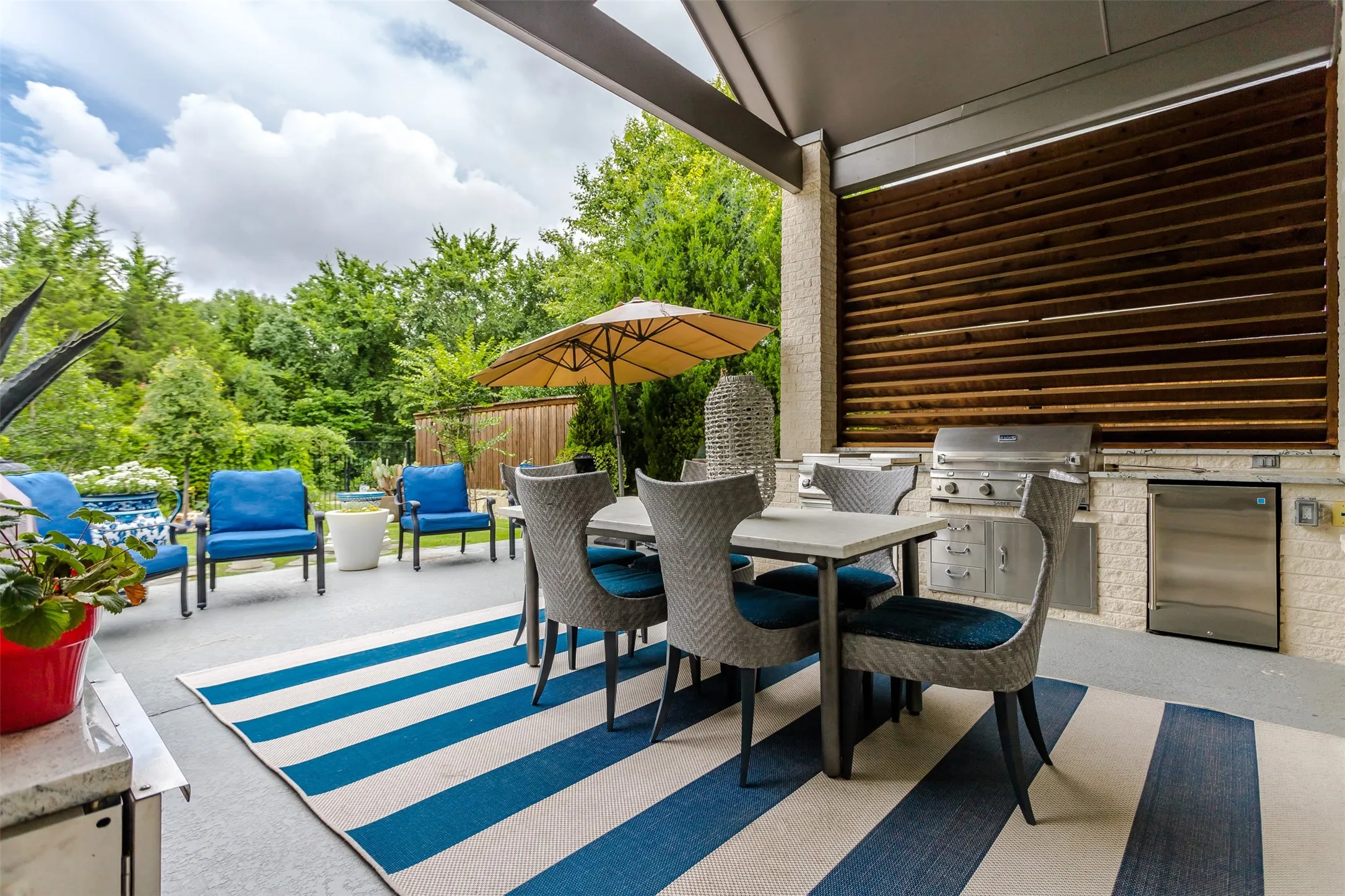 Covered patio with an outdoor kitchen featuring a built-in grill and stainless steel appliances