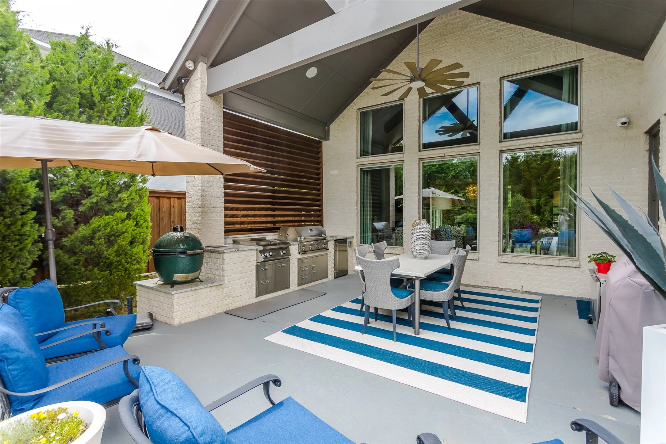 Covered patio featuring an outdoor kitchen with built-in grills, a dedicated cooking station, and ample counter space