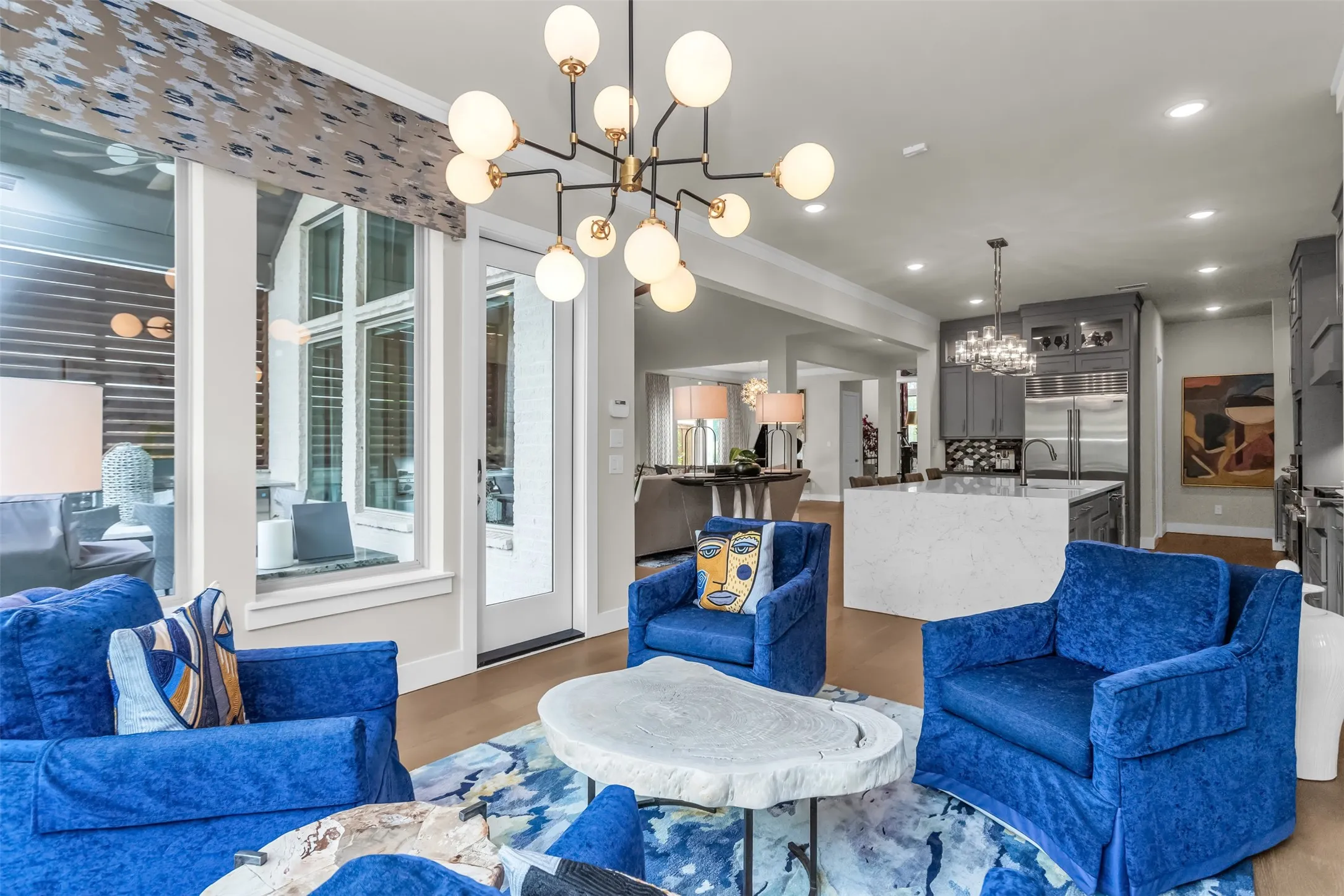 Open-concept living space with wood-finish flooring, a contemporary chandelier, and recessed lighting