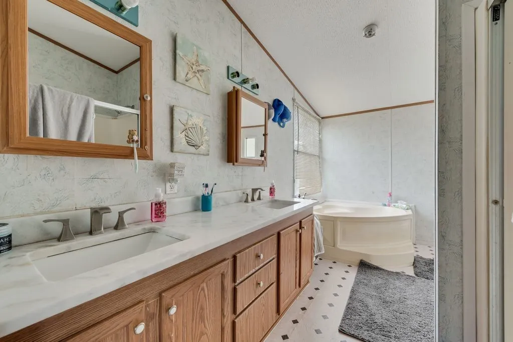 Primary bathroom has been updated with granite countertops too and connects to the walk in closet