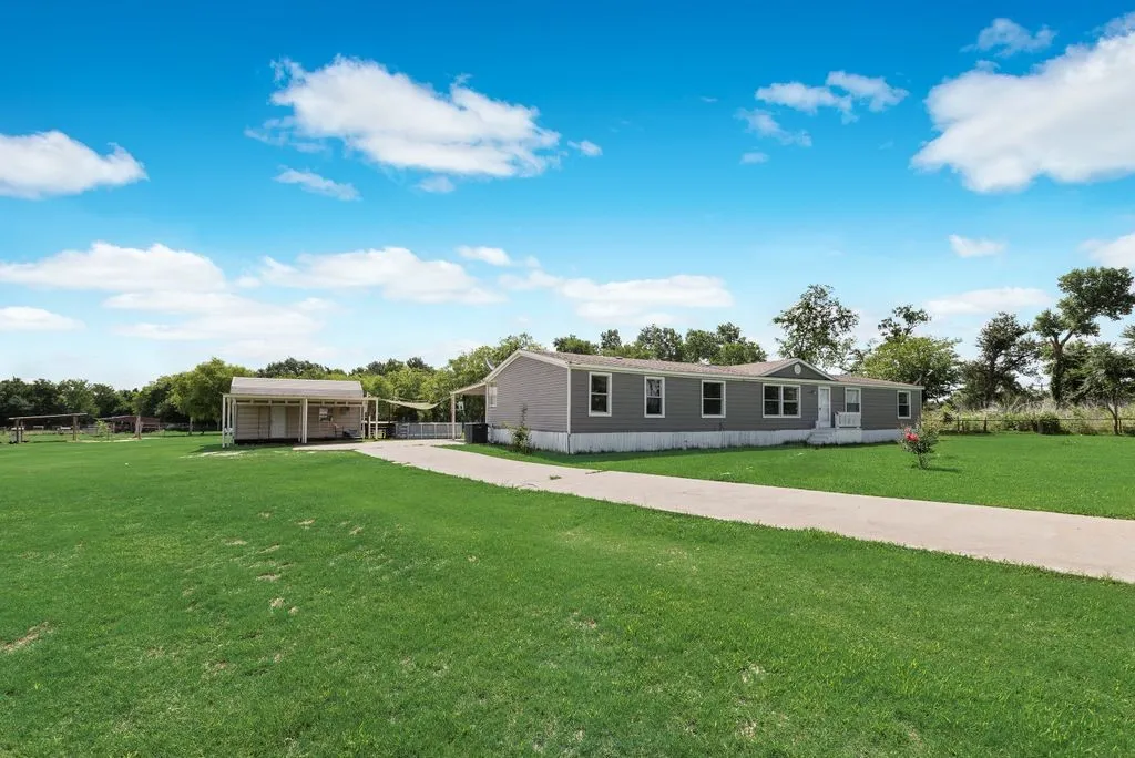 Concrete driveway on a dead end road with outbuilding with carport and attached carport behind the home. Plenty of parking for farm equipment!