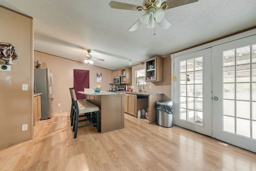 Kitchen has updated granite countertops and french doors leading to the outdoor kitchen and attached carport