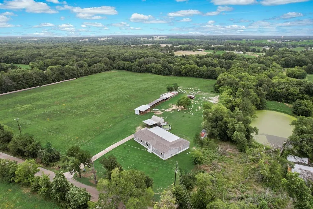 One side is a hay field and the other is a vacant lot with pond