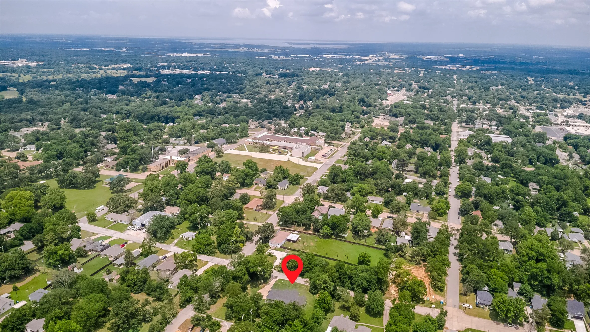 Aerial perspective of a residential neighborhood with a clear marker indicating the property's location