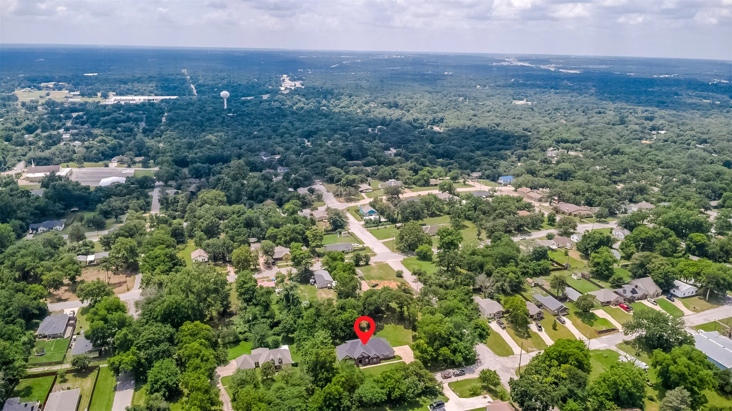 Aerial perspective showcasing a residential property nestled within a tree-lined neighborhood