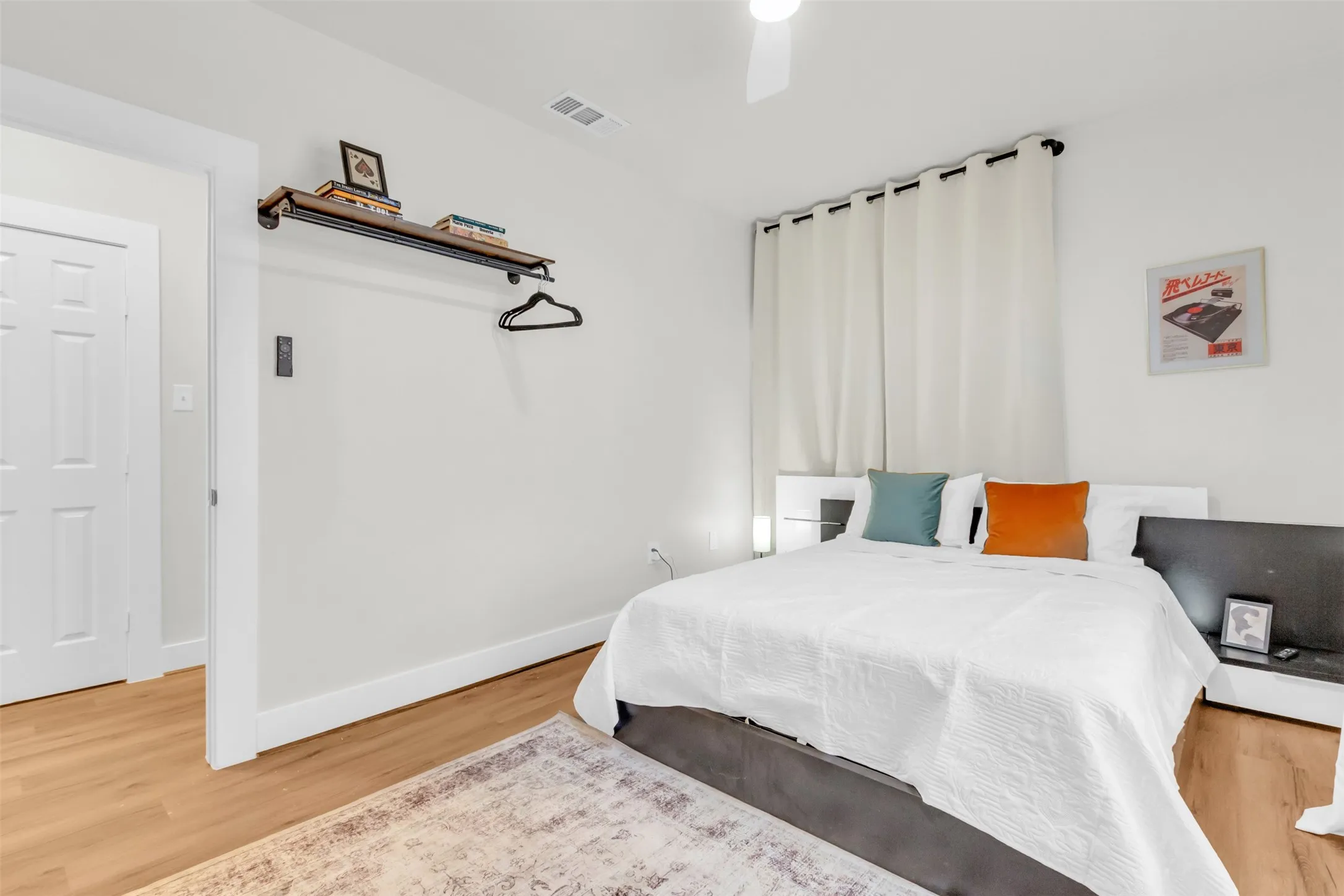 Bedroom featuring wood-finish flooring, a ceiling fan, and white walls