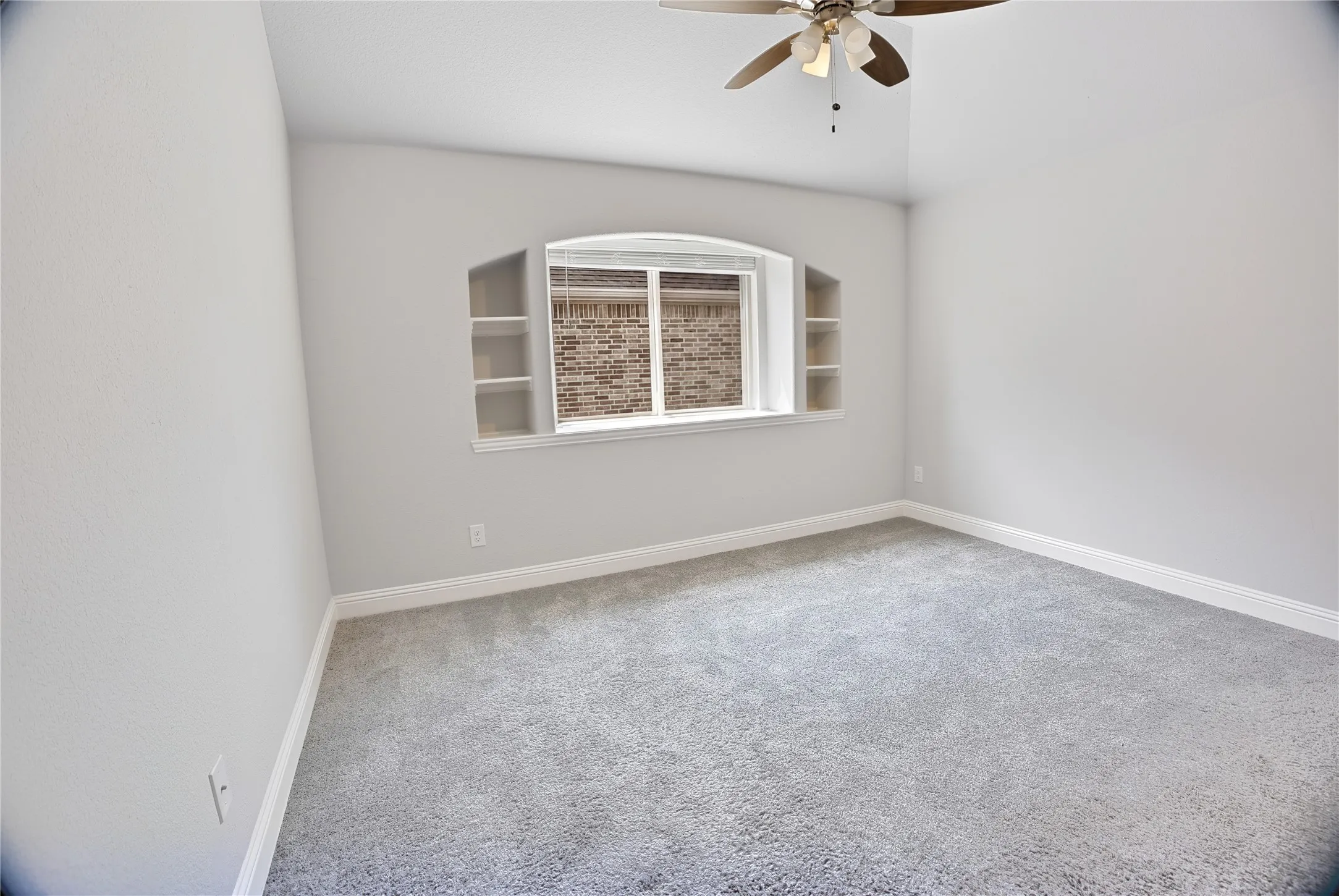 Light gray carpeting with white baseboards and neutral wall paint