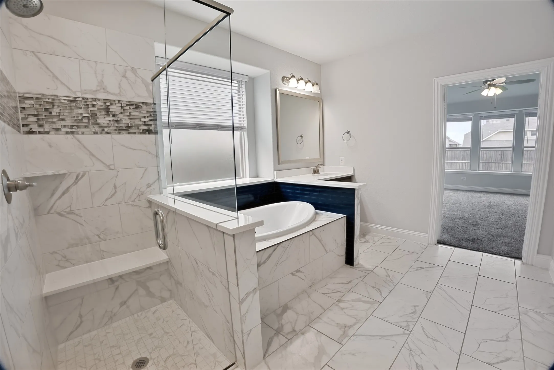 Contemporary bathroom featuring a walk-in shower with a glass enclosure, a built-in bench, and a mosaic tile accent band