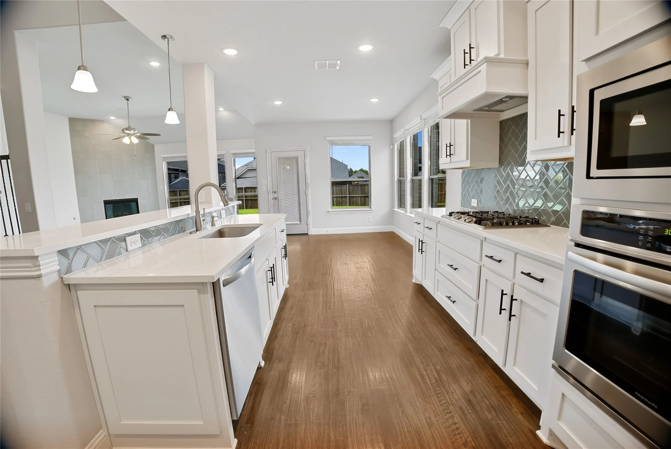 Modern kitchen featuring white cabinetry, light-toned countertops, and stainless steel appliances