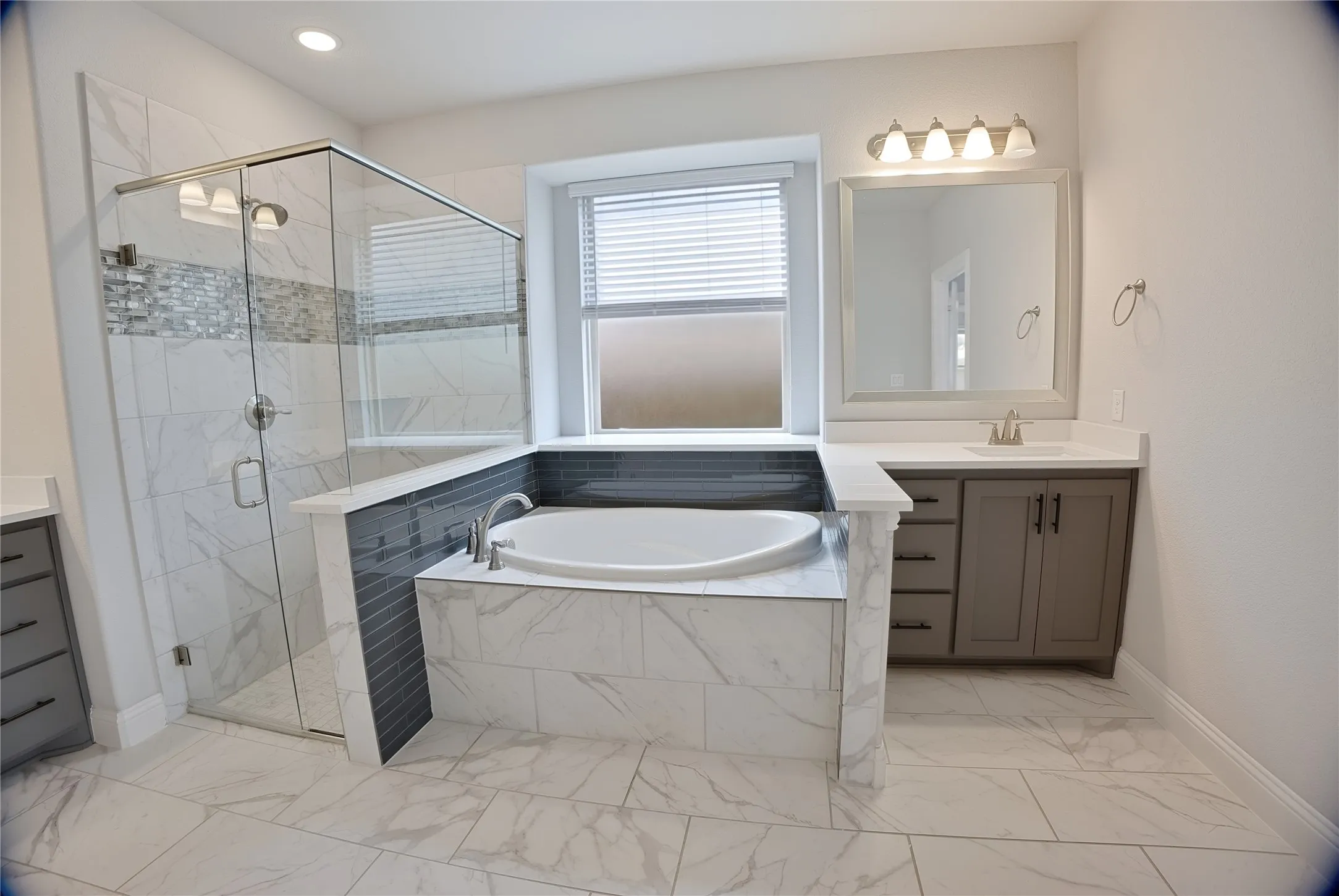 Spacious bathroom featuring a glass-enclosed shower with tile surround, separate soaking tub, and a single vanity with storage