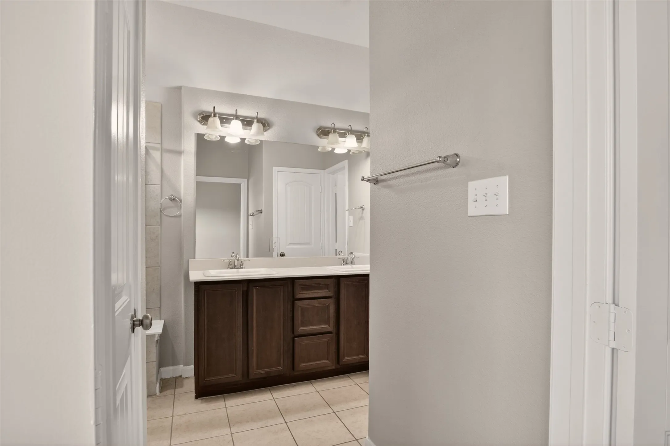 Bathroom featuring a dual vanity with a dark wood-finish cabinet and integrated sinks