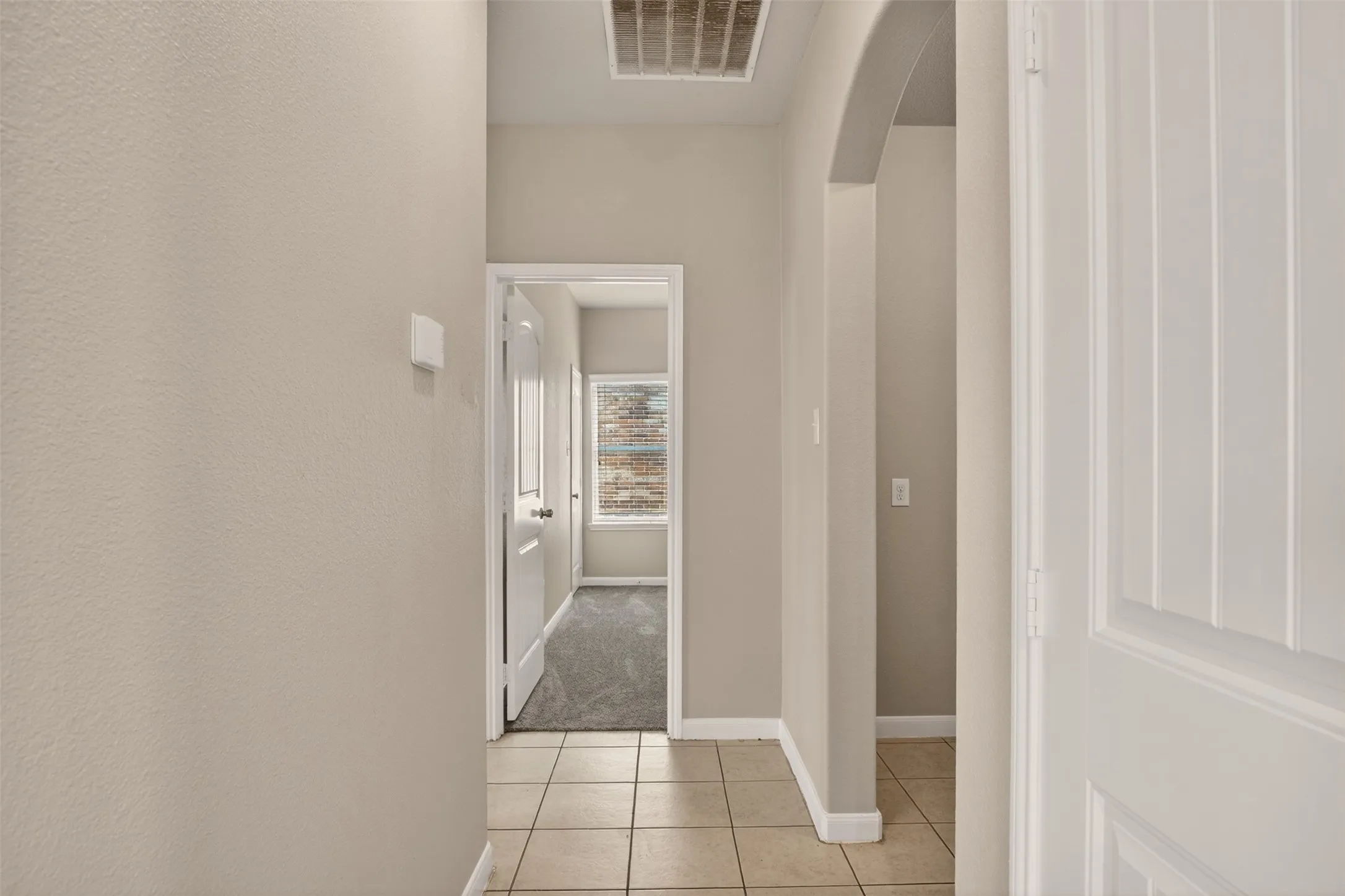 Entryway featuring neutral-toned walls, tile flooring, and white trim