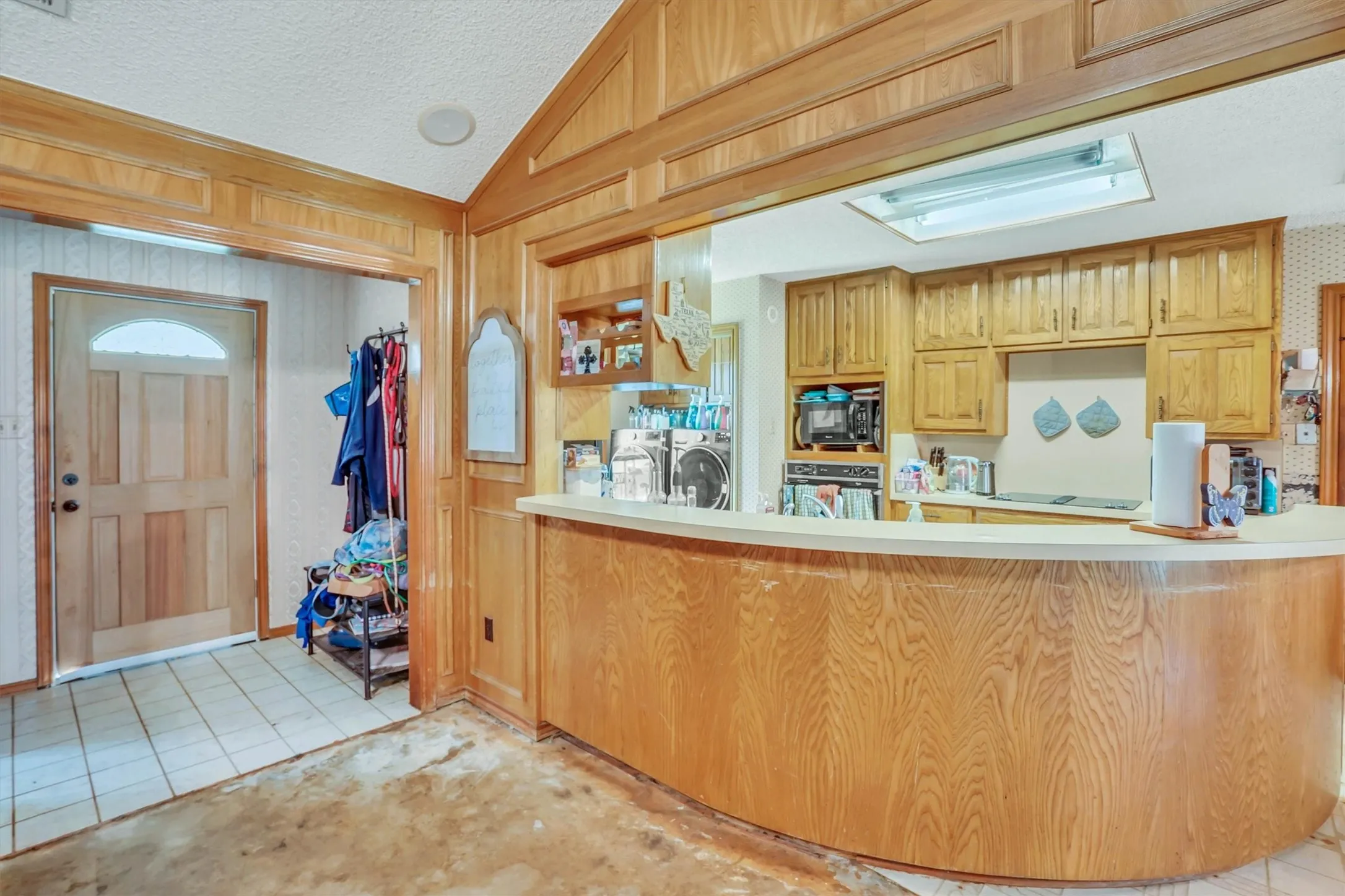 Kitchen featuring wood-finish cabinetry, built-in appliances, and a skylight
