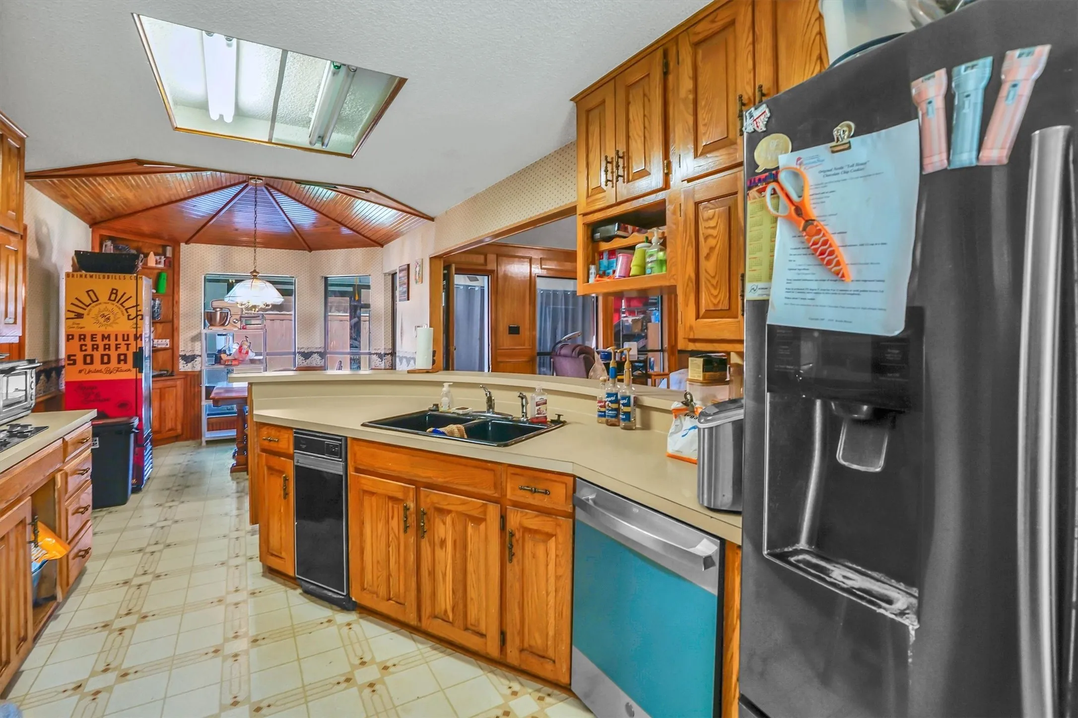 Kitchen featuring wood cabinetry, a skylight, and a built-in double sink