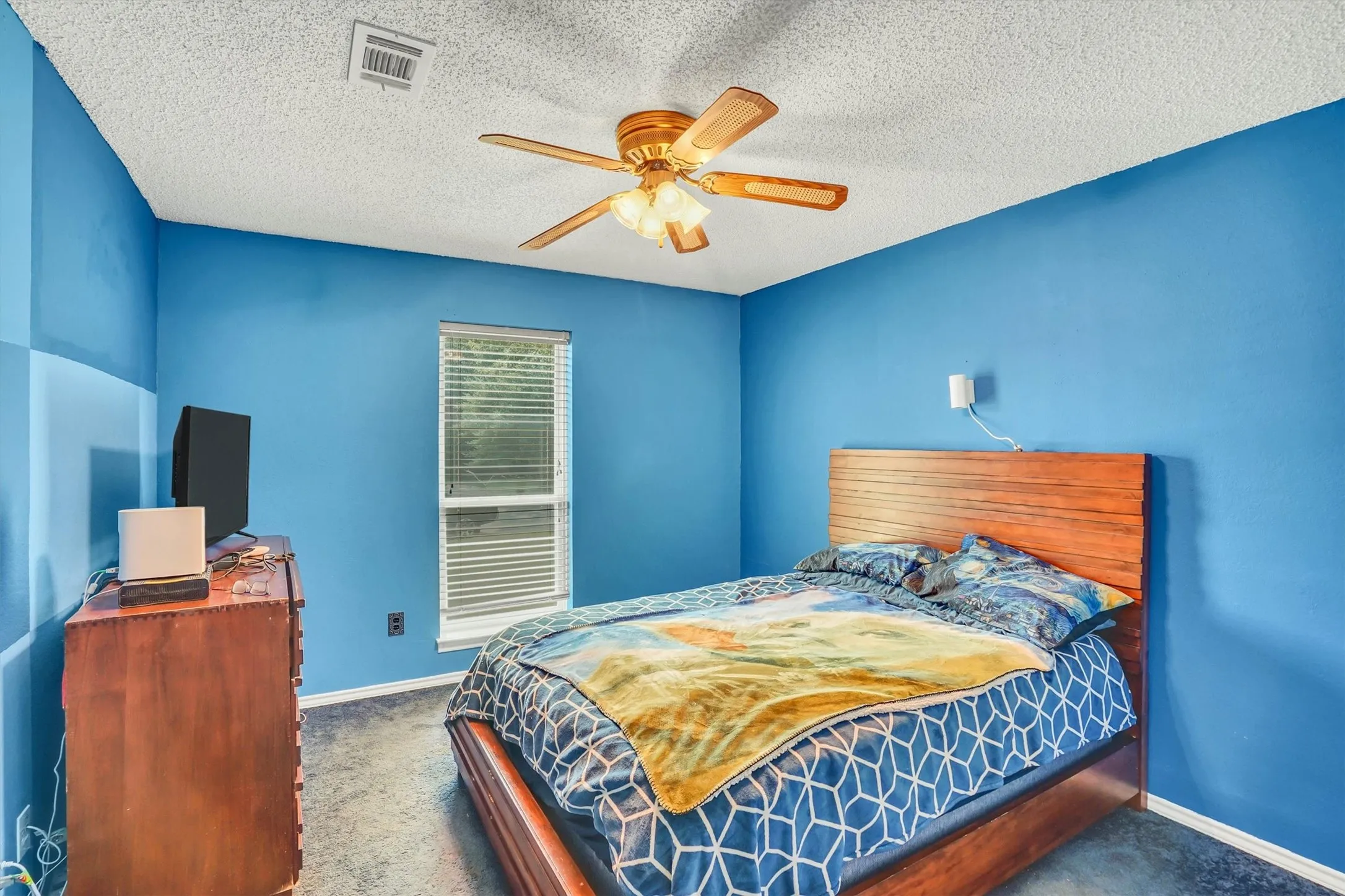 Room with blue walls, carpeted flooring, and a window with blinds