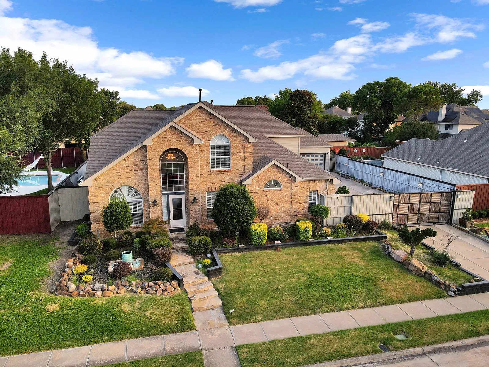 Brick facade residence with a prominent arched window above the entry
