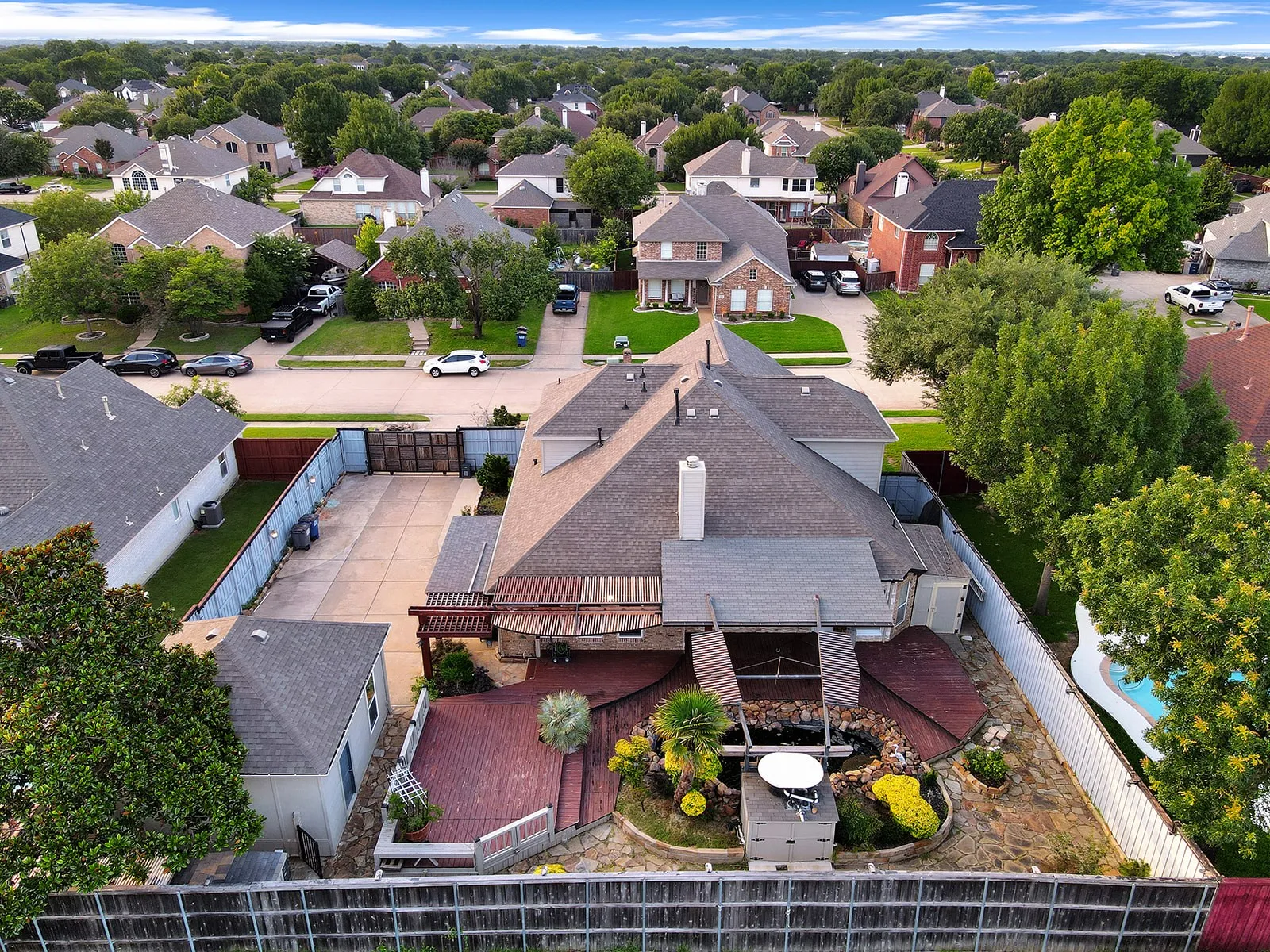 Expansive backyard with multi-level wood decking, water feature, and mature landscaping