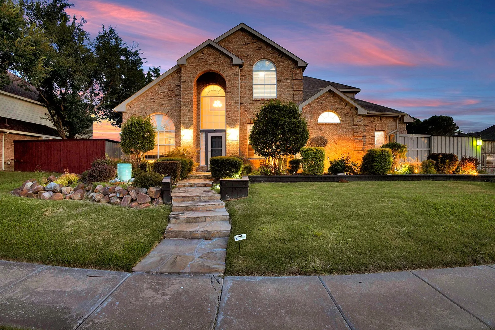 Brick exterior residence featuring an arched entry window and front door