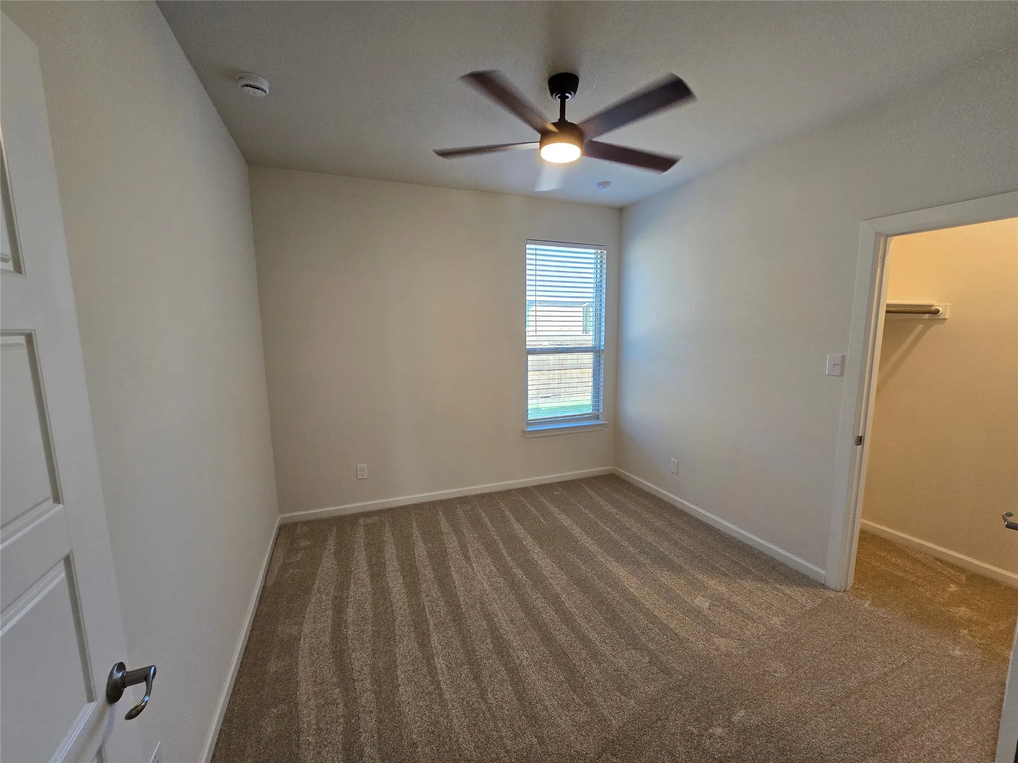 Neutral tone walls complement the patterned carpet