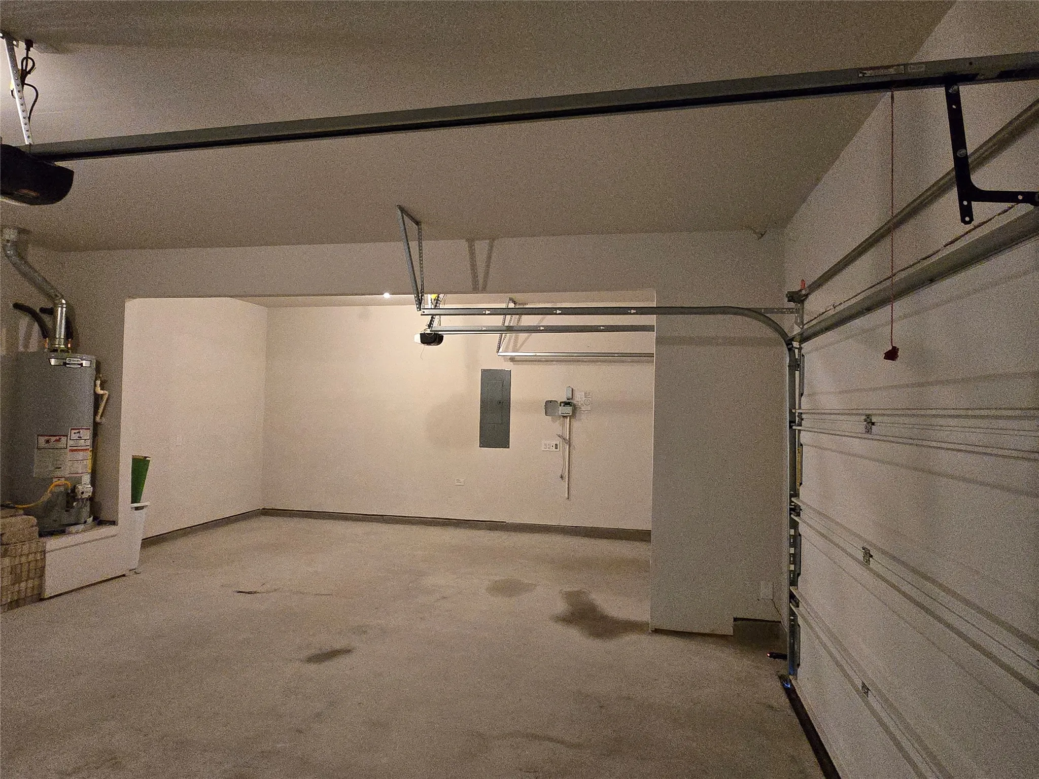 Spacious garage featuring a concrete floor, painted walls, and an overhead garage door with track system