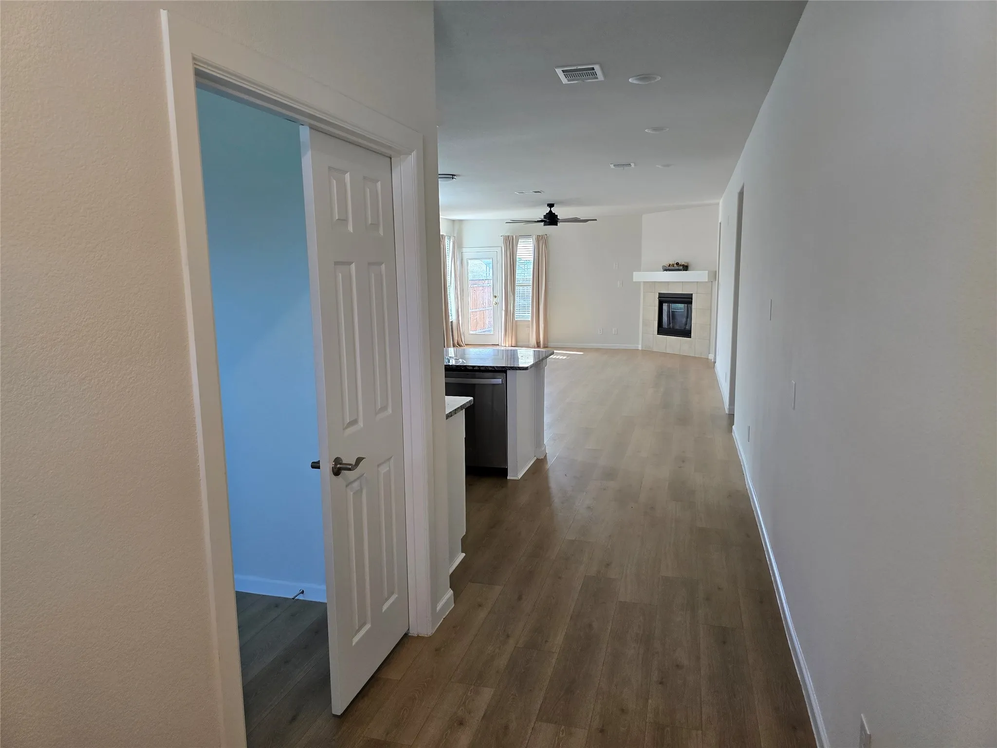 Open concept living space featuring wood-finish flooring, a fireplace with a mantel, and recessed lighting