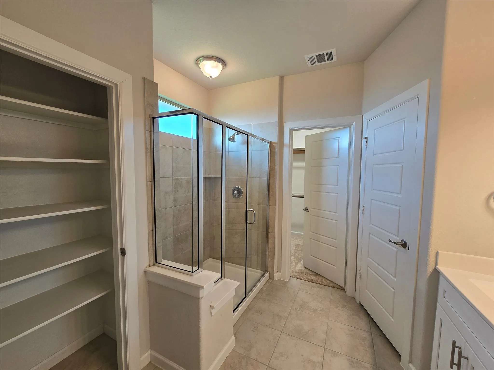 Glass-enclosed shower with tiled walls and a built-in niche