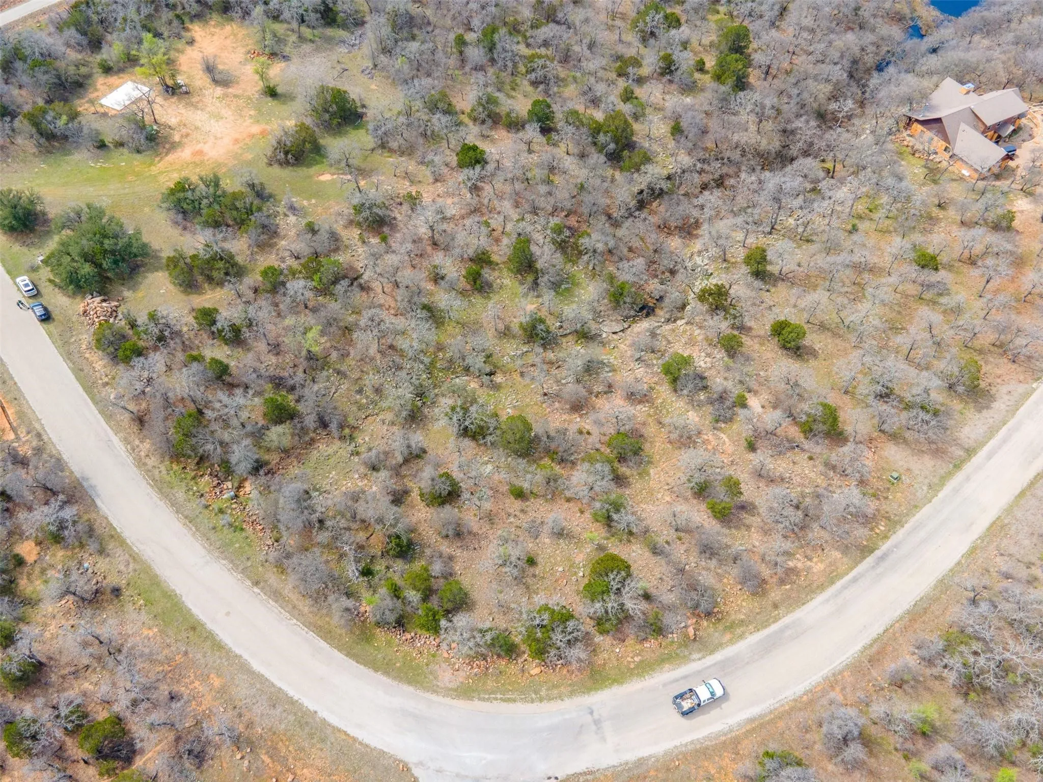 Aerial view of 2.87-acre corner lot in The Ranches at Clayton Mountain, Gordon TX, showing flat building area, gully, and small stream