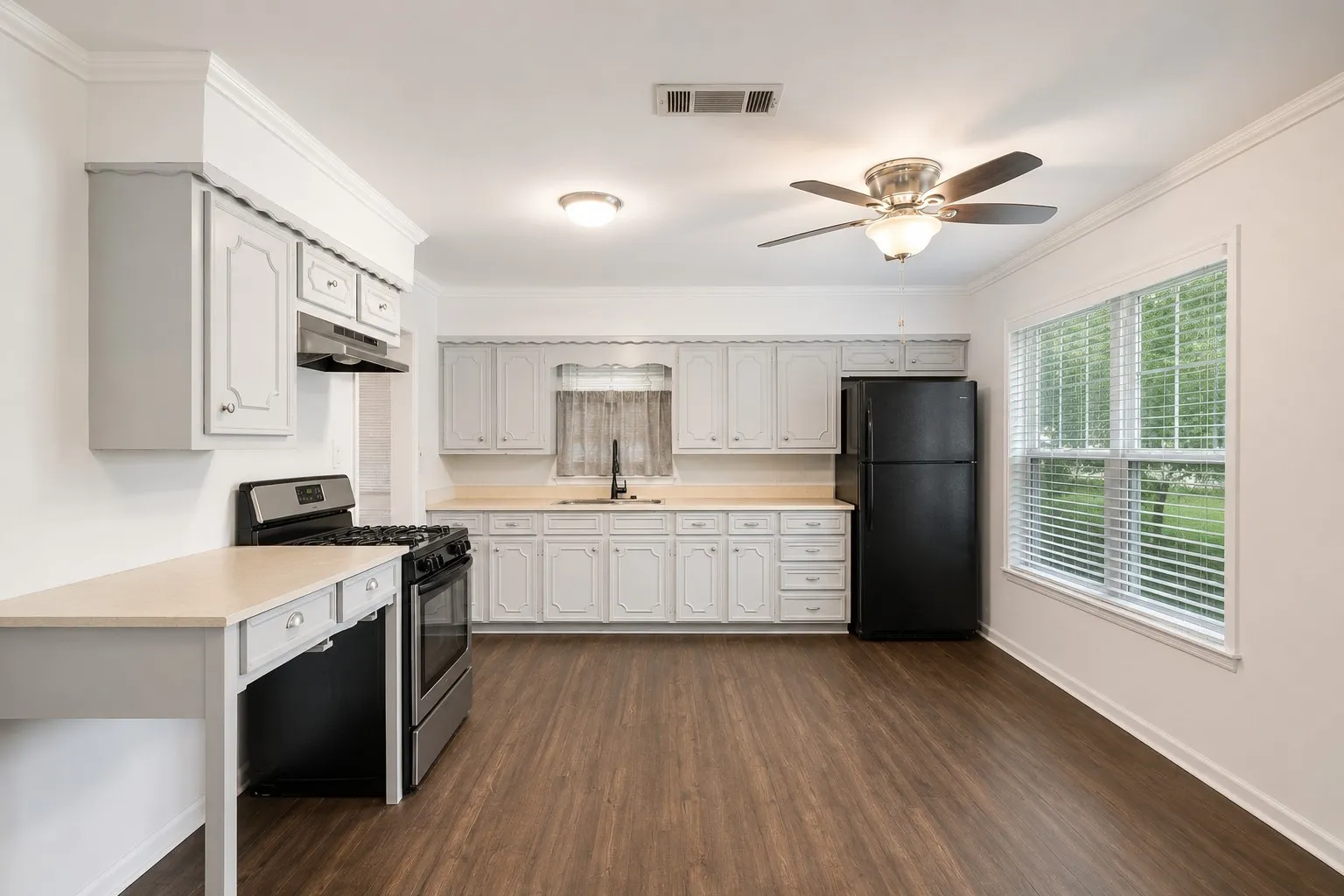 Bright kitchen featuring wood-finish flooring, light cabinetry, and light countertops