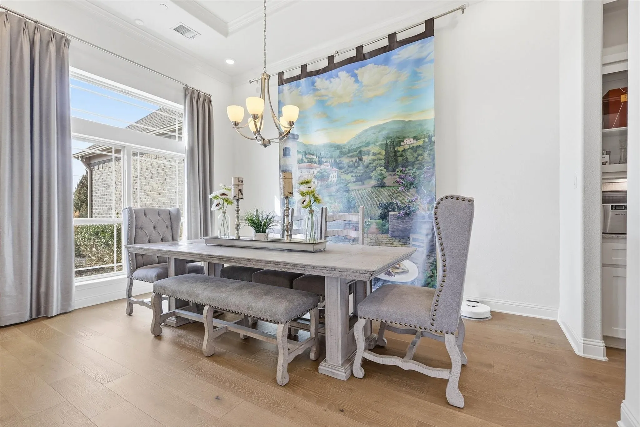 Dining area featuring wood-finish flooring, a tray ceiling, and a multi-light chandelier