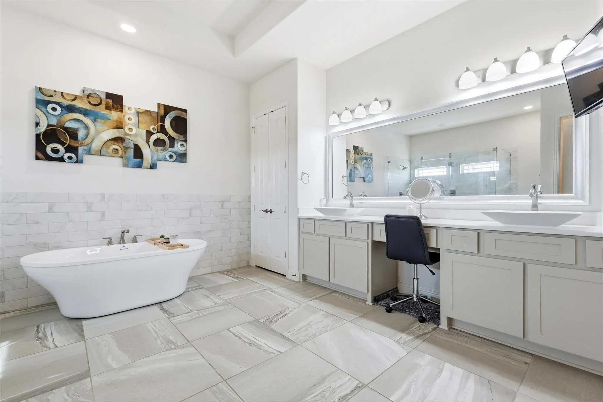 Freestanding soaking tub with floor-to-ceiling tiled wall