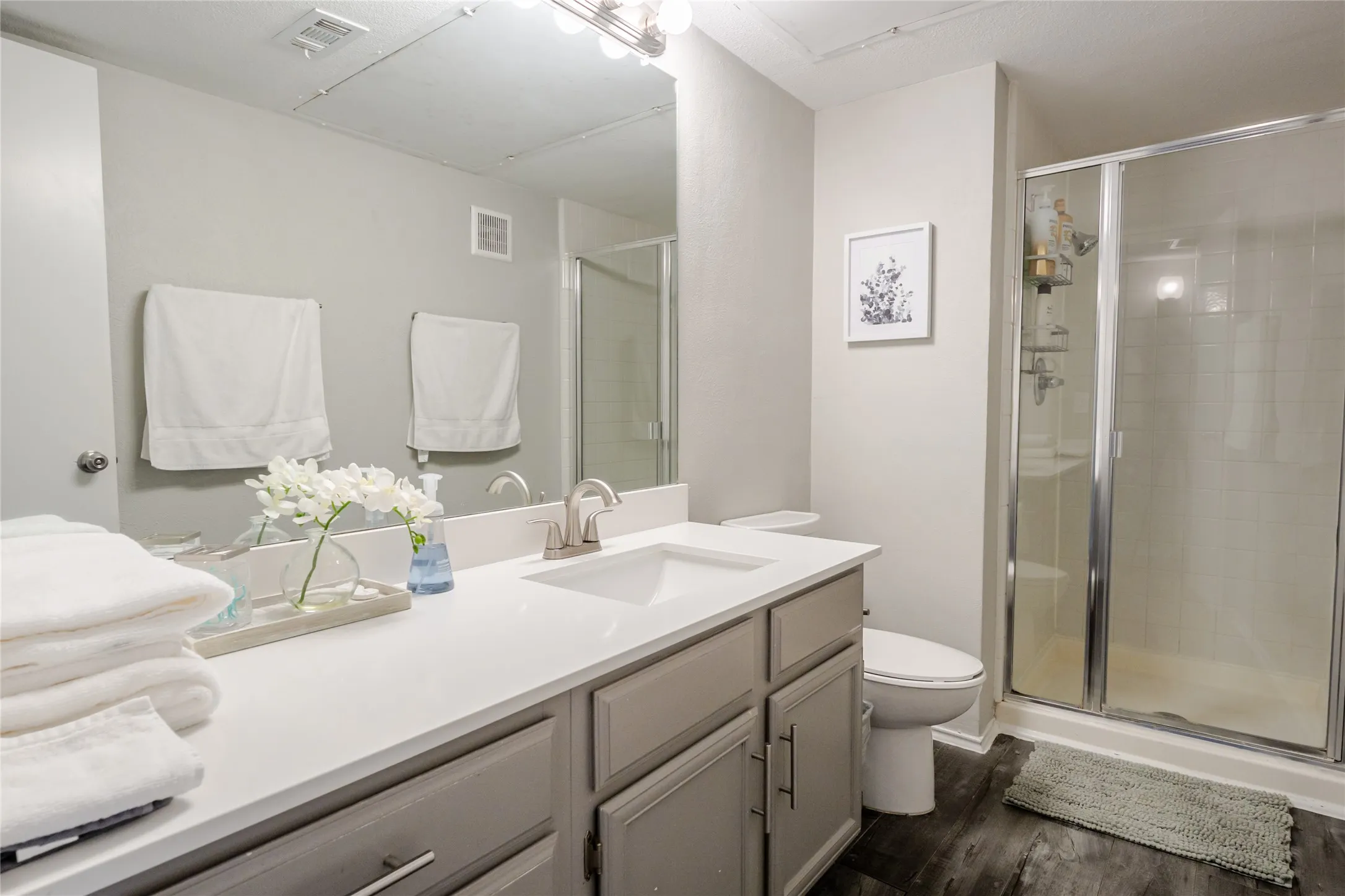 Full bathroom with a single vanity, integrated sink, and brushed nickel fixtures