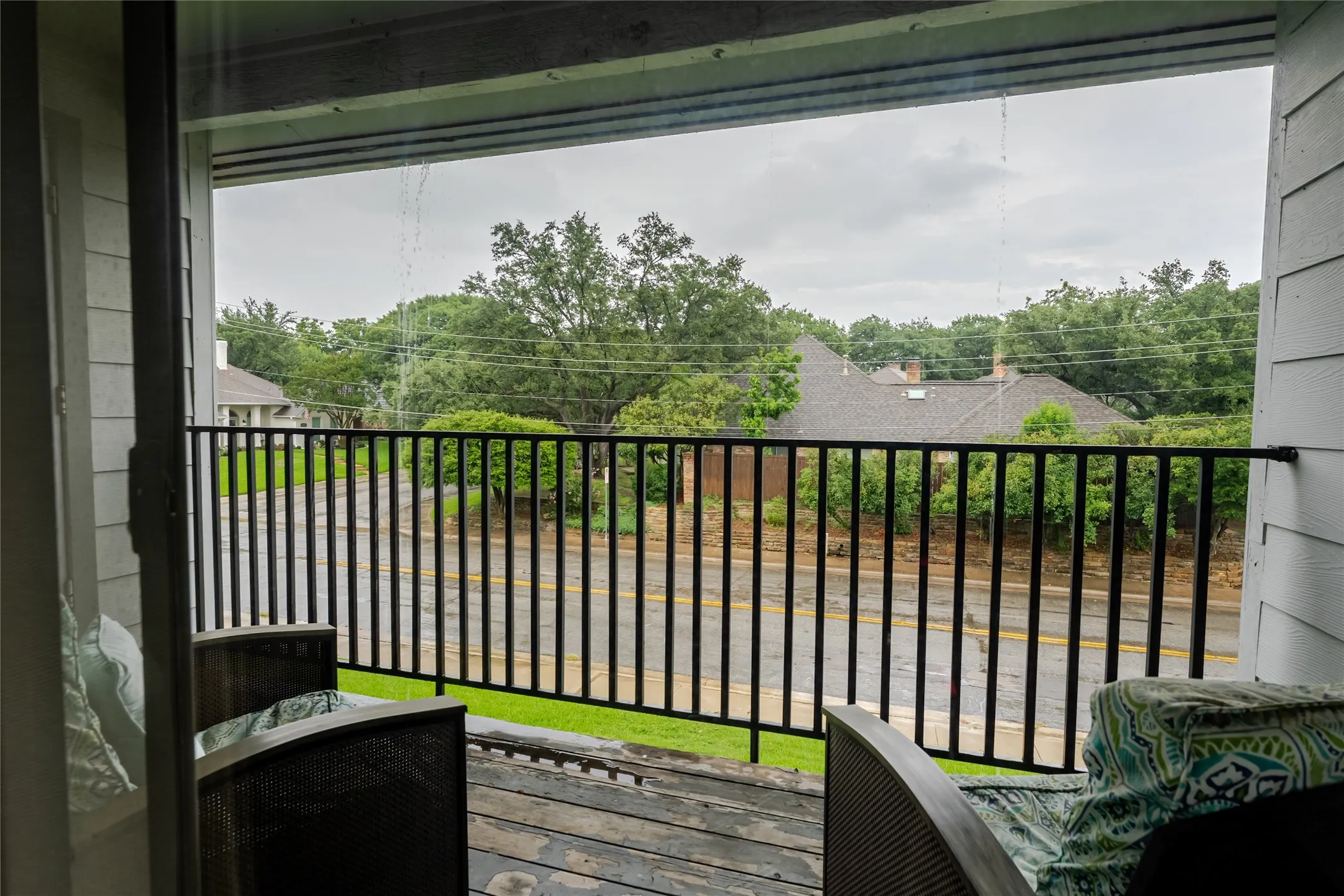 Balcony with a black metal railing and wood-finish flooring