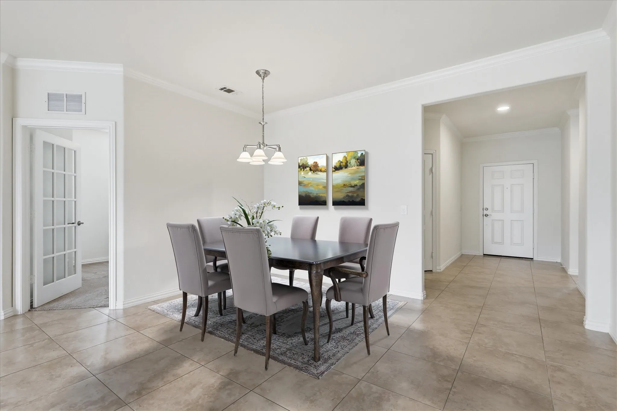 Staged Dining area featuring tile flooring, white walls, and a multi-light chandelier