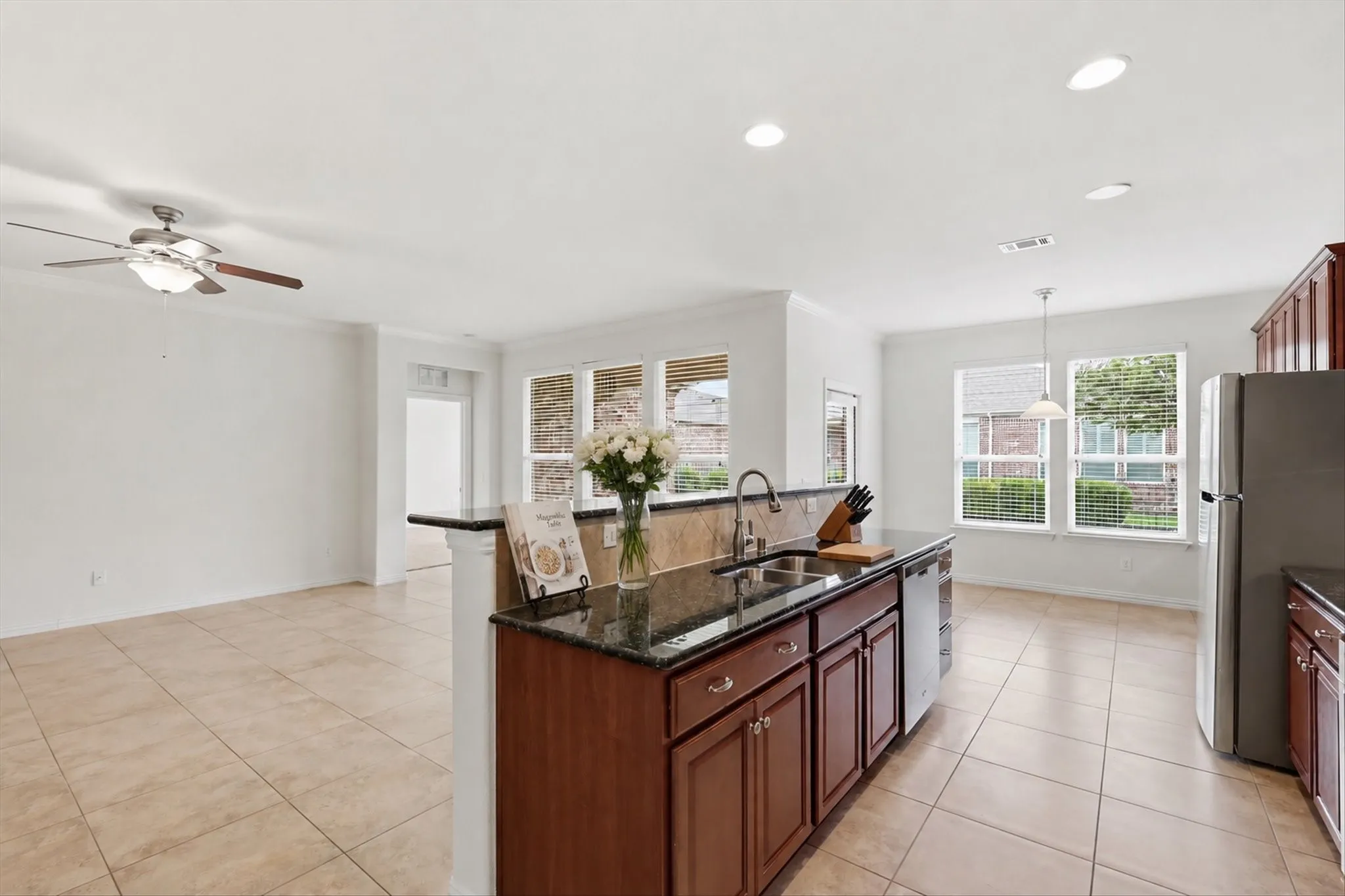 Kitchen island featuring a dark countertop, undermount sink, and rich wood cabinetry
