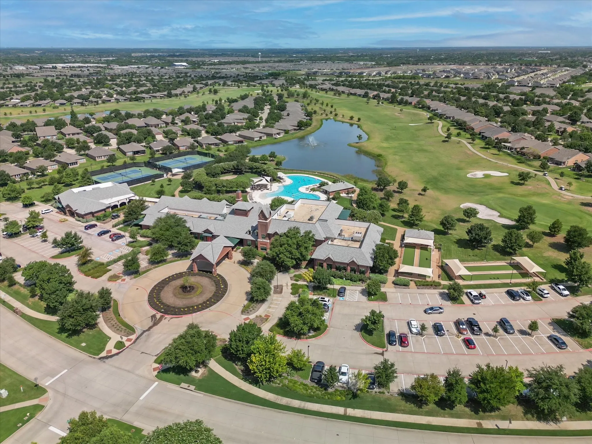 Frisco Lakes community clubhouse featuring multiple buildings, extensive parking, and a circular driveway entrance