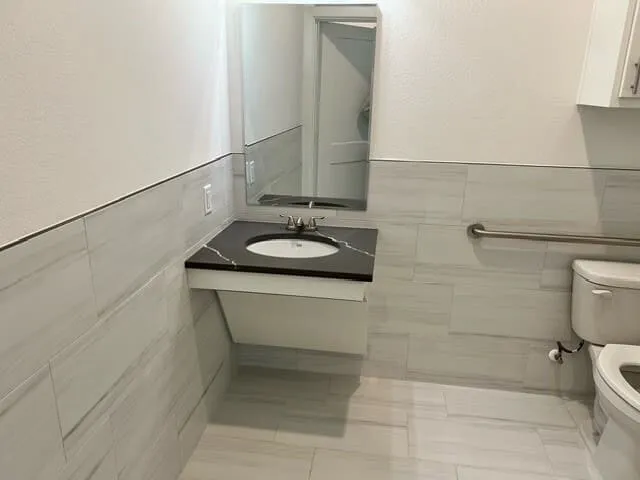 Bathroom featuring a floating vanity with a dark countertop and undermount sink
