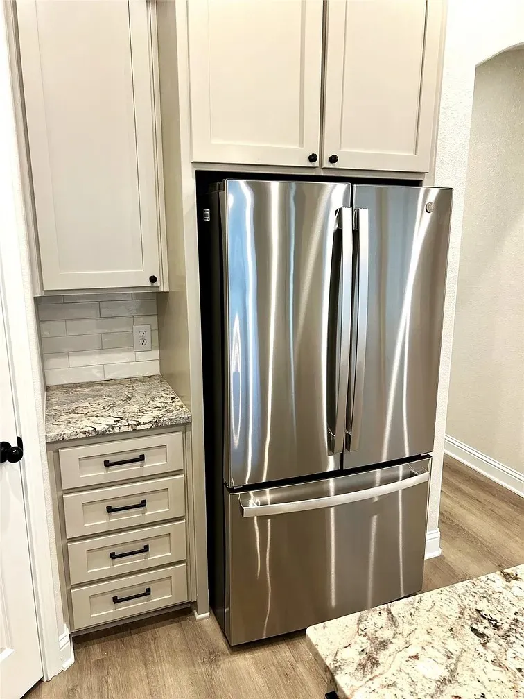 Stainless steel French door refrigerator set within custom cabinetry