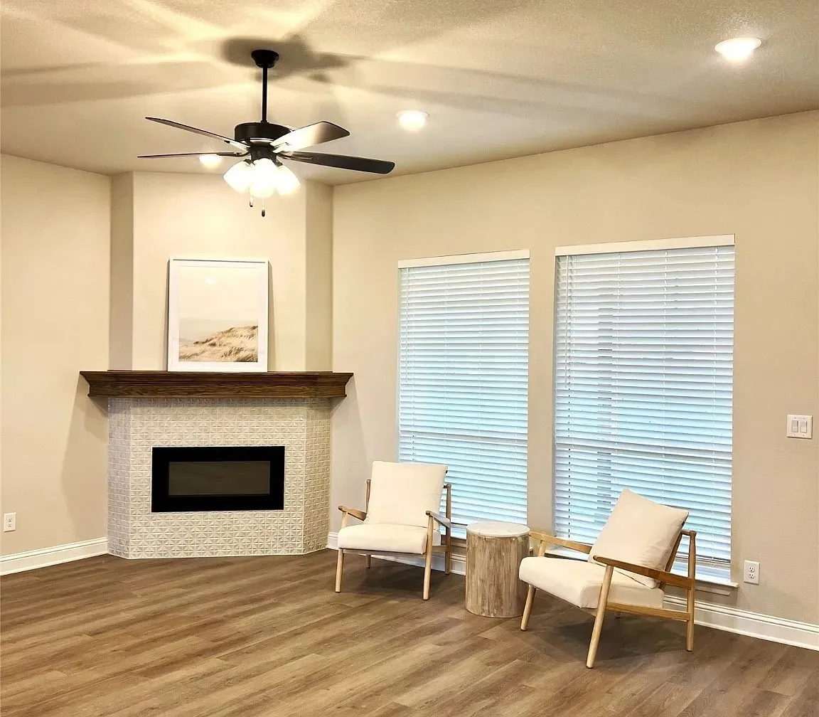 Corner fireplace with decorative tile surround and a dark wood mantel