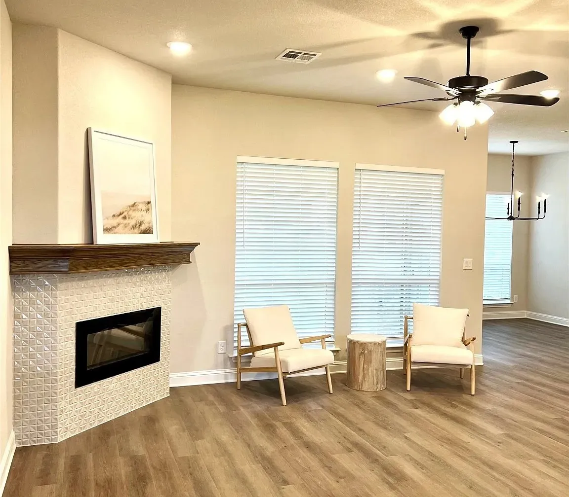 Living space with wood-finish flooring, recessed lighting, and a ceiling fan with light fixture