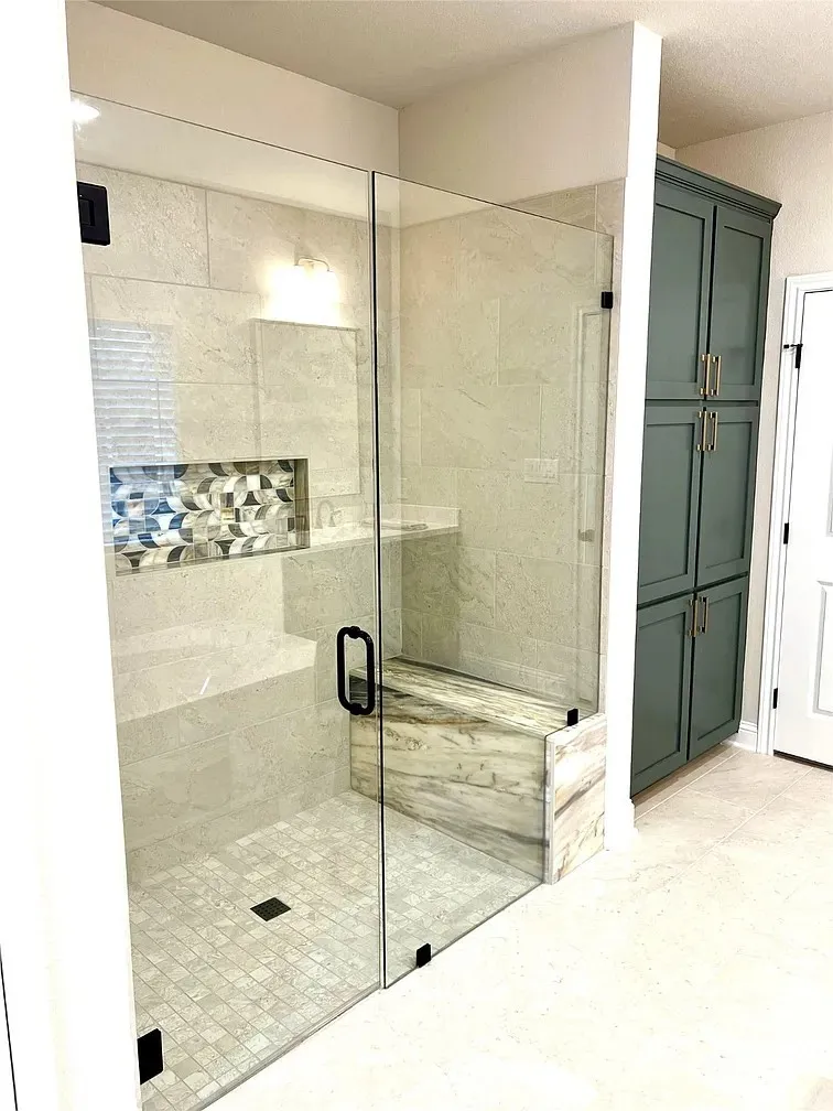 Spacious shower enclosure with clear glass panels and matte black hardware