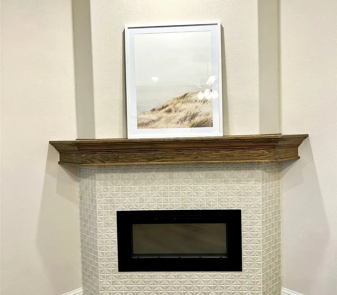 Corner fireplace with a wood-finish mantel and a white geometric tiled surround