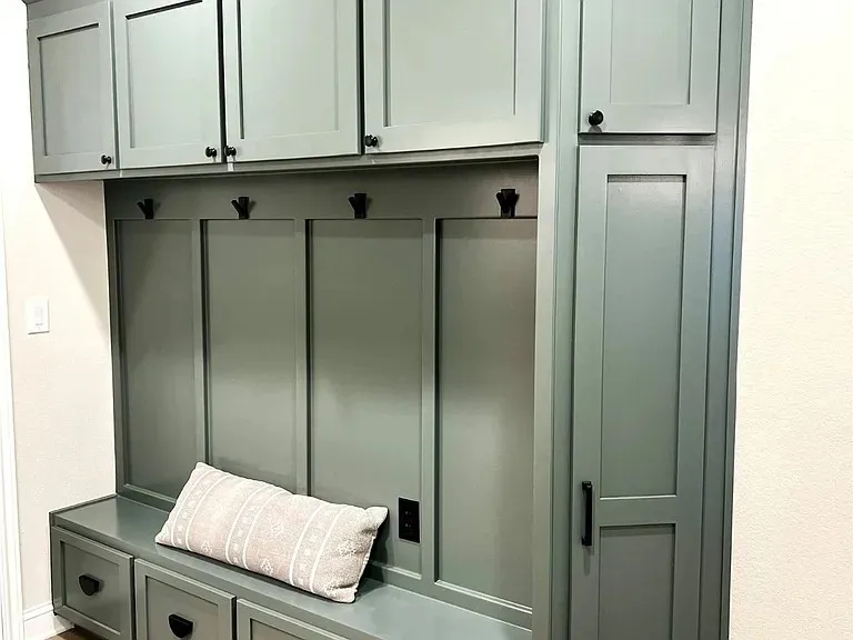 Built-in cabinetry with a bench, integrated coat hooks, upper storage, and lower drawer storage