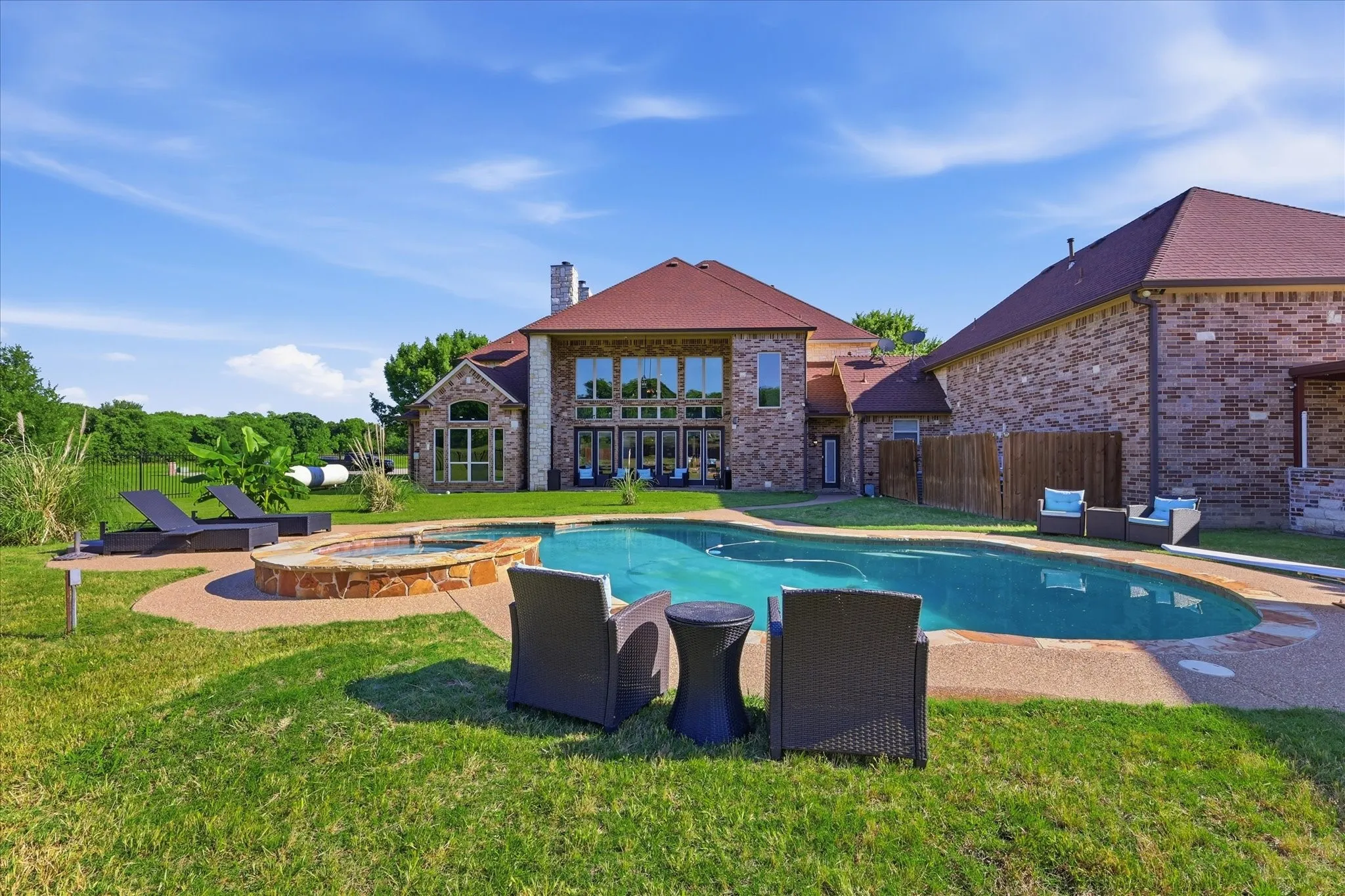 Expansive backyard featuring a custom-shaped swimming pool, and integrated spa
