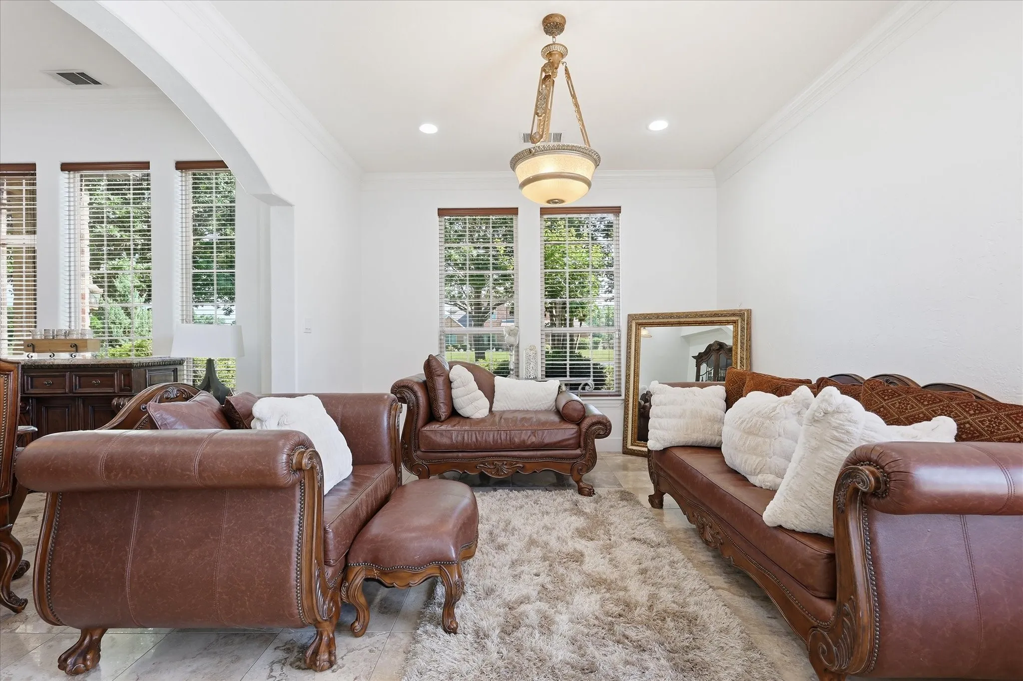 Bright interior space featuring light-toned flooring, white walls, and a decorative ceiling light fixture