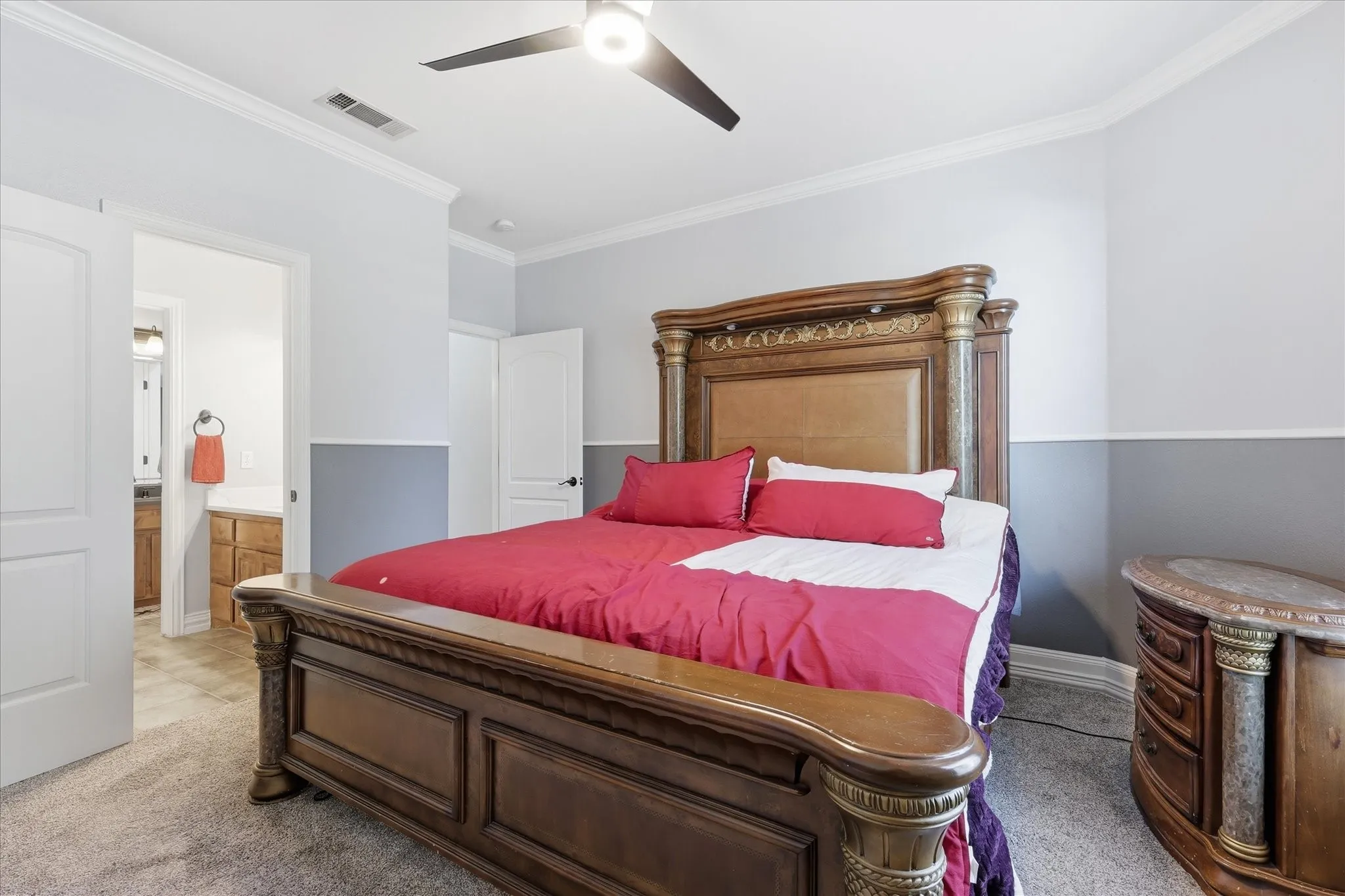 Bedroom featuring two-tone wall paint, crown molding, and a ceiling fan