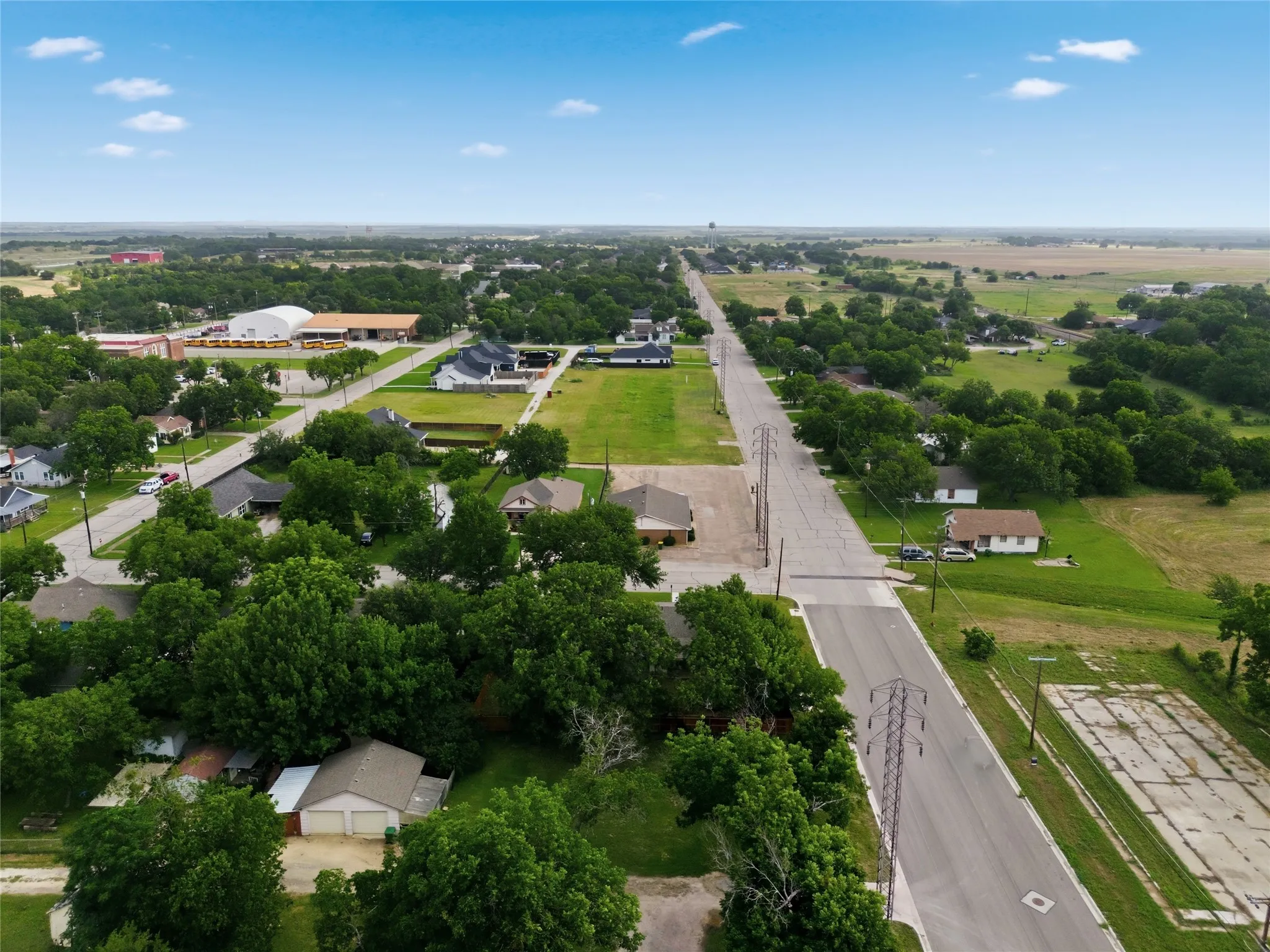 Aerial perspective of a residential area featuring mature trees and expansive green spaces