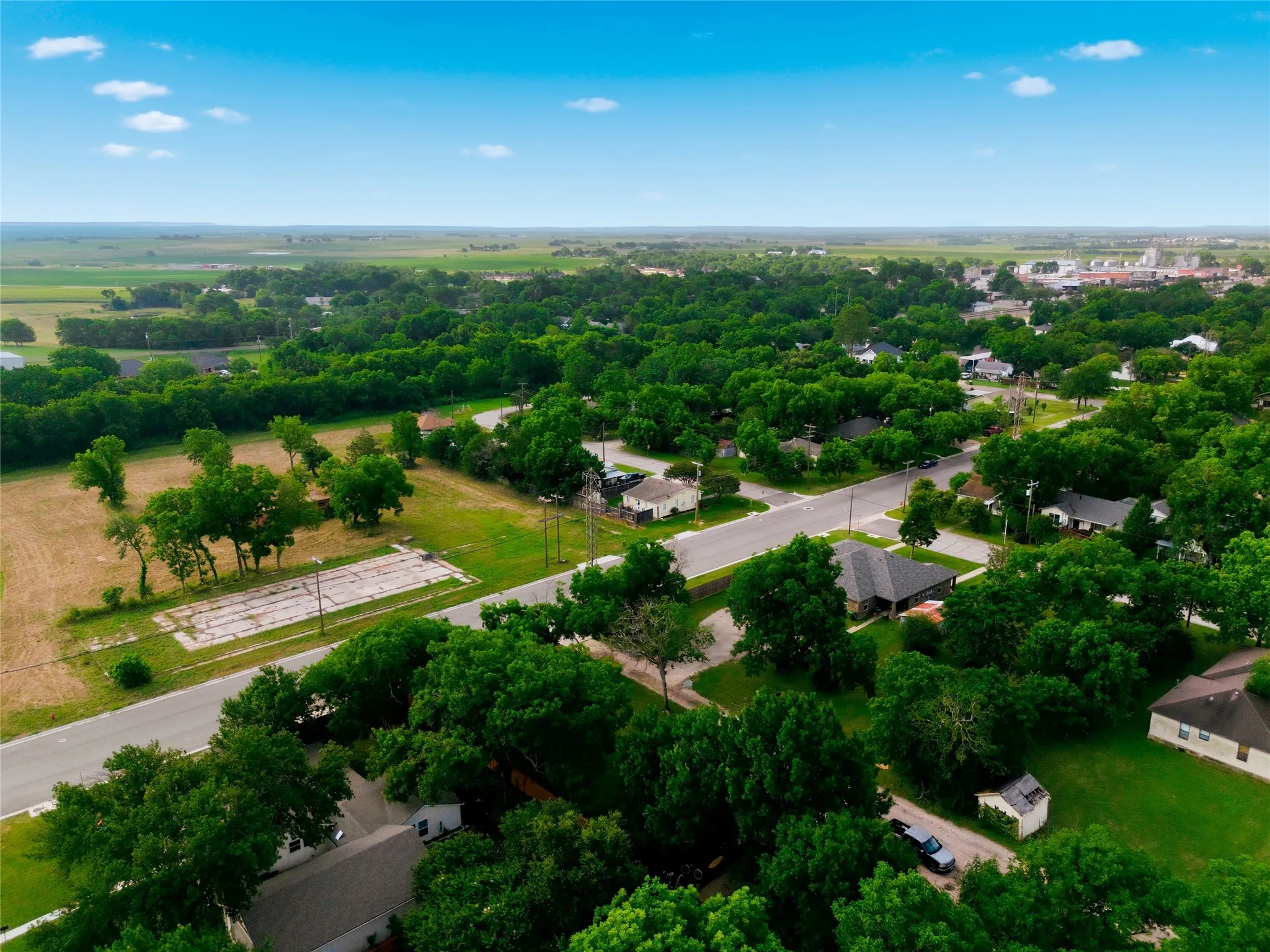 Expansive aerial perspective showcasing a residential area with abundant mature trees and a clear blue sky
