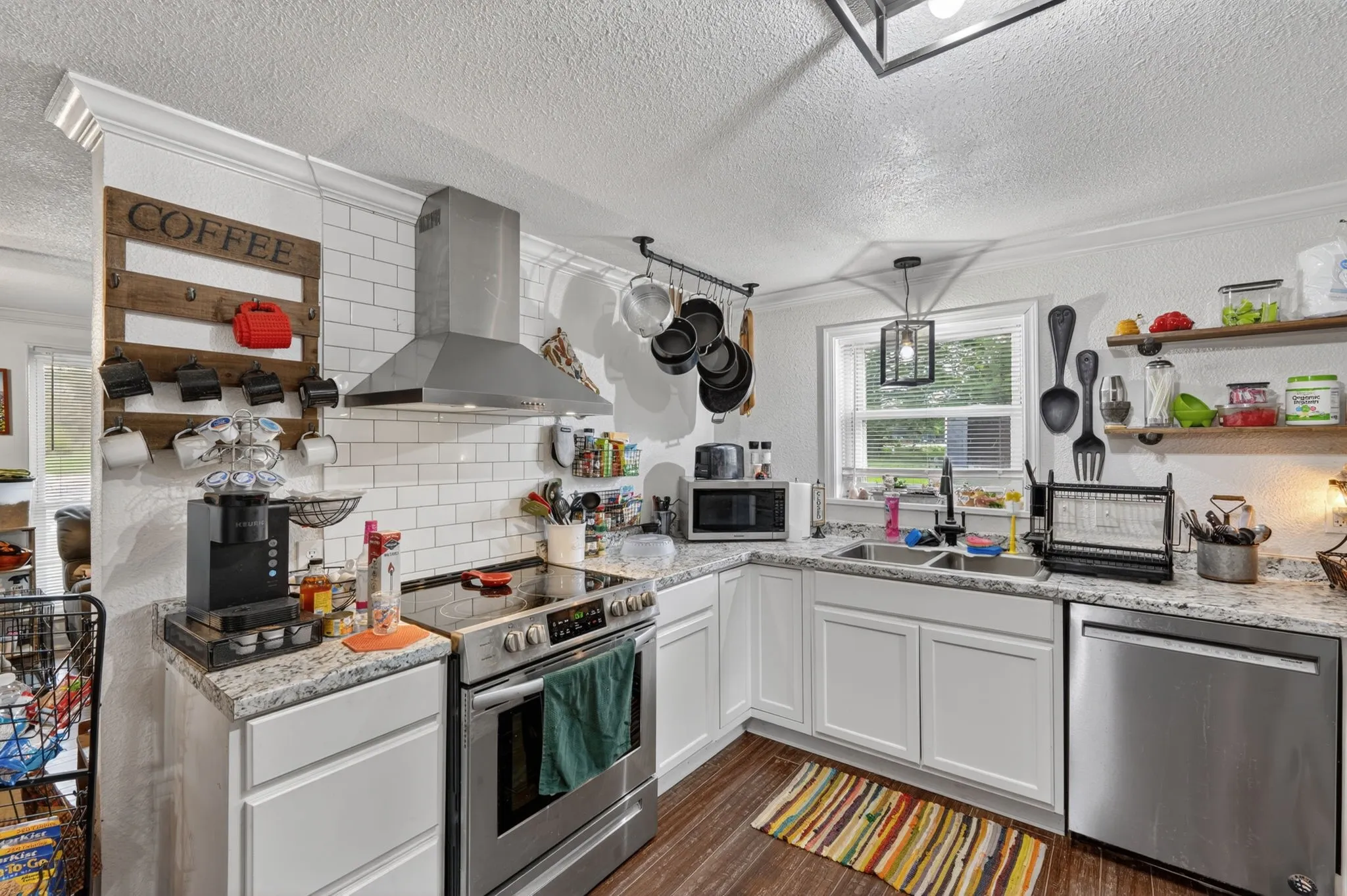 Kitchen featuring white shaker-style cabinetry, light-toned countertops, and wood-finish flooring