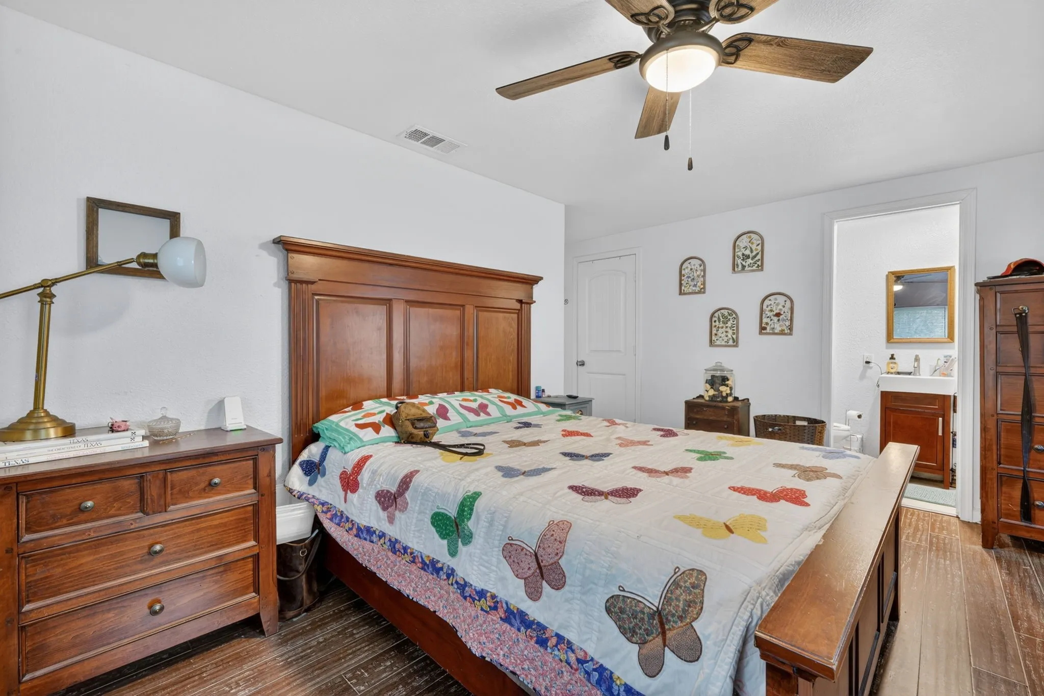 Bedroom featuring wood-finish flooring, a ceiling fan with integrated lighting, and a white interior door